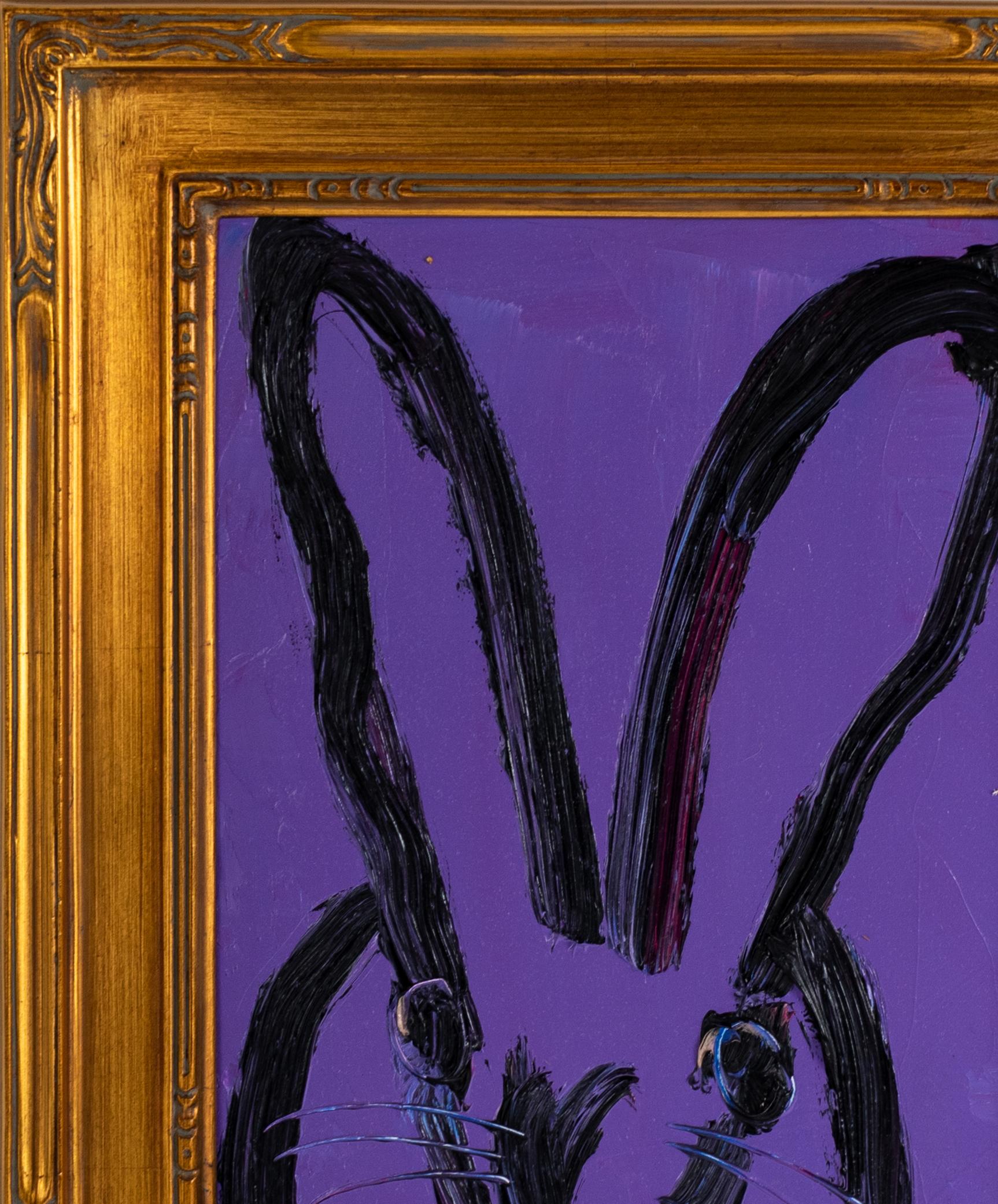 Deep purple background with lots of under layers of paint with a black outline bunny portrait in an ornate gold frame.