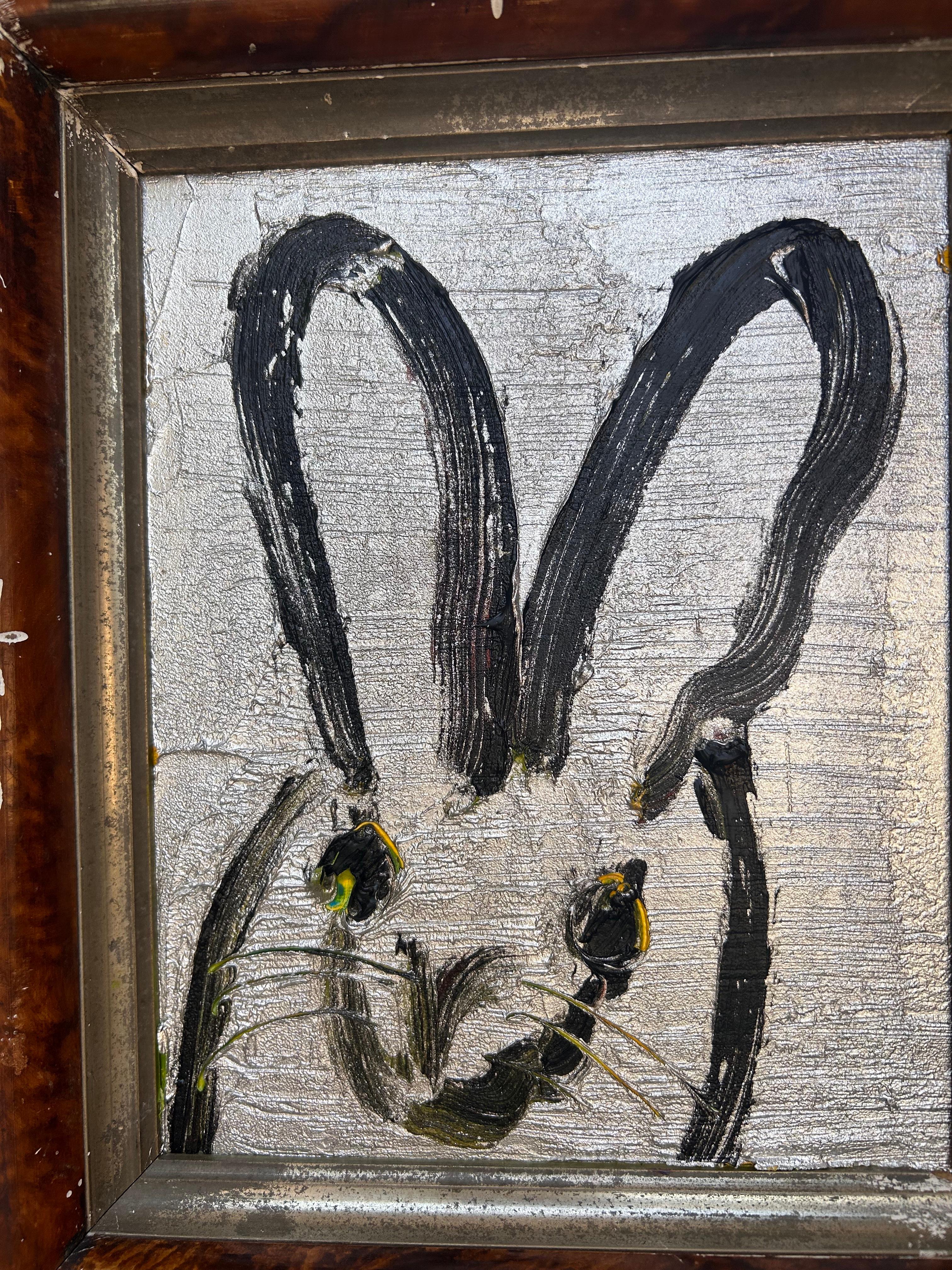 Une magnifique composition de l'un des sujets les plus emblématiques d'Icone, les lapins. Cette pièce représente une figure gestuelle d'un lapin noir sur un fond argenté avec des détails vert clair et jaunes. Le tableau est placé dans un magnifique