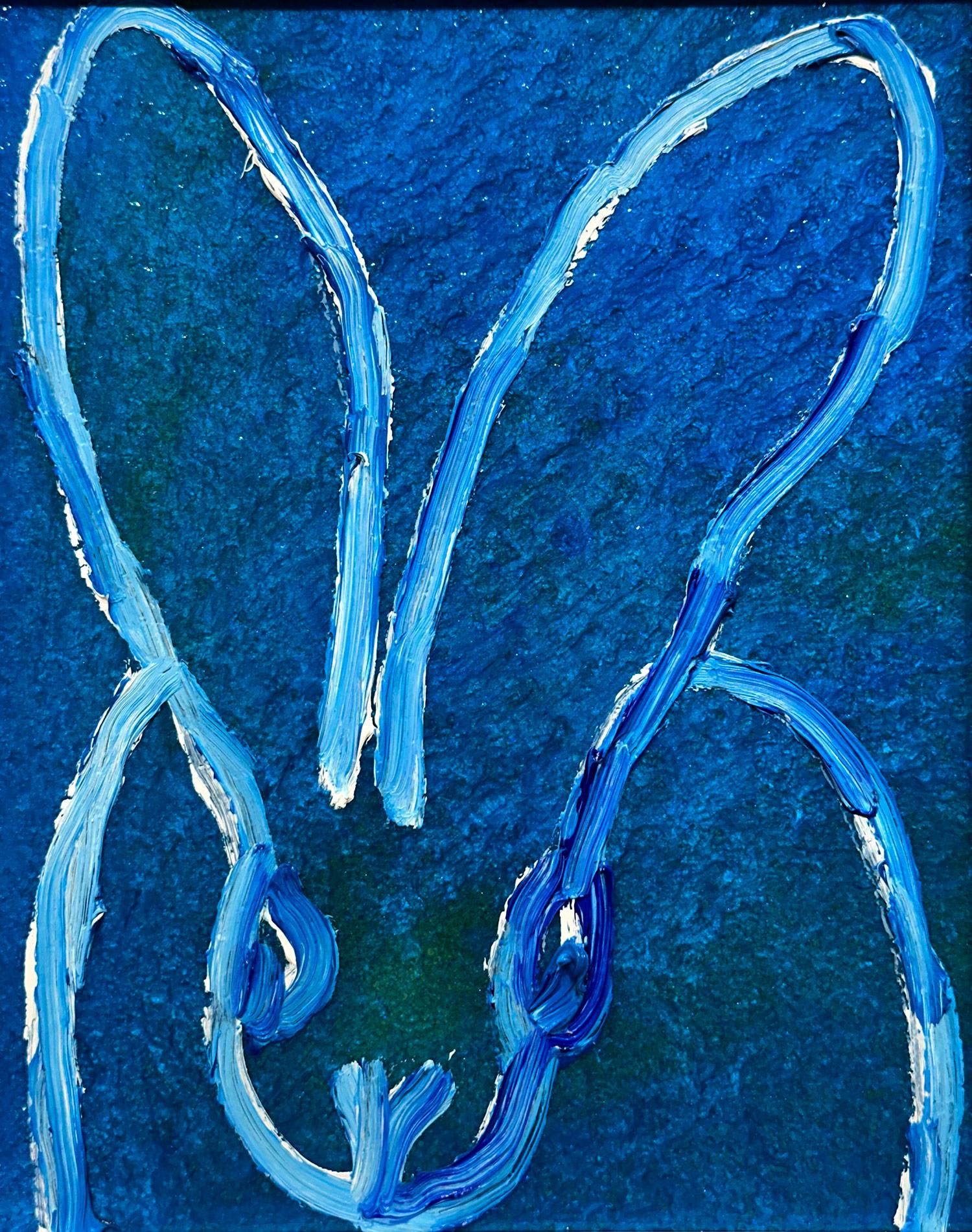 A wonderful composition of one of Slonem's most iconic subjects, Bunnies. This piece depicts a gestural figure of a white bunny on a Sapphire Blue background with thick use of paint. It is housed in a wonderful simple white contemporary wood frame.