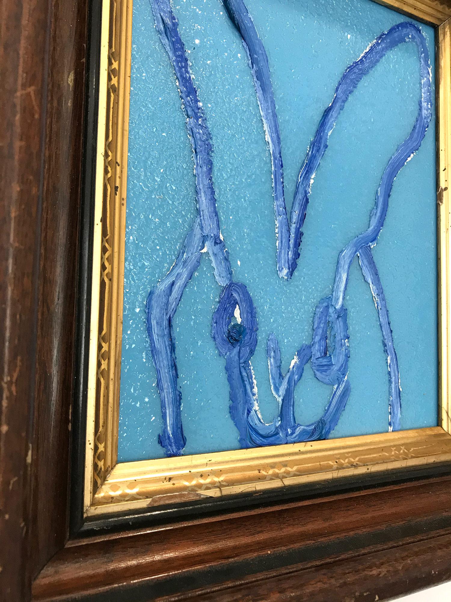 A wonderful composition of one of Slonem's most iconic subjects, Bunnies. This piece depicts a gestural figure of a light blue bunny on an light cobalt blue background with thick use of paint and diamond dust. It is housed in a wonderful antique