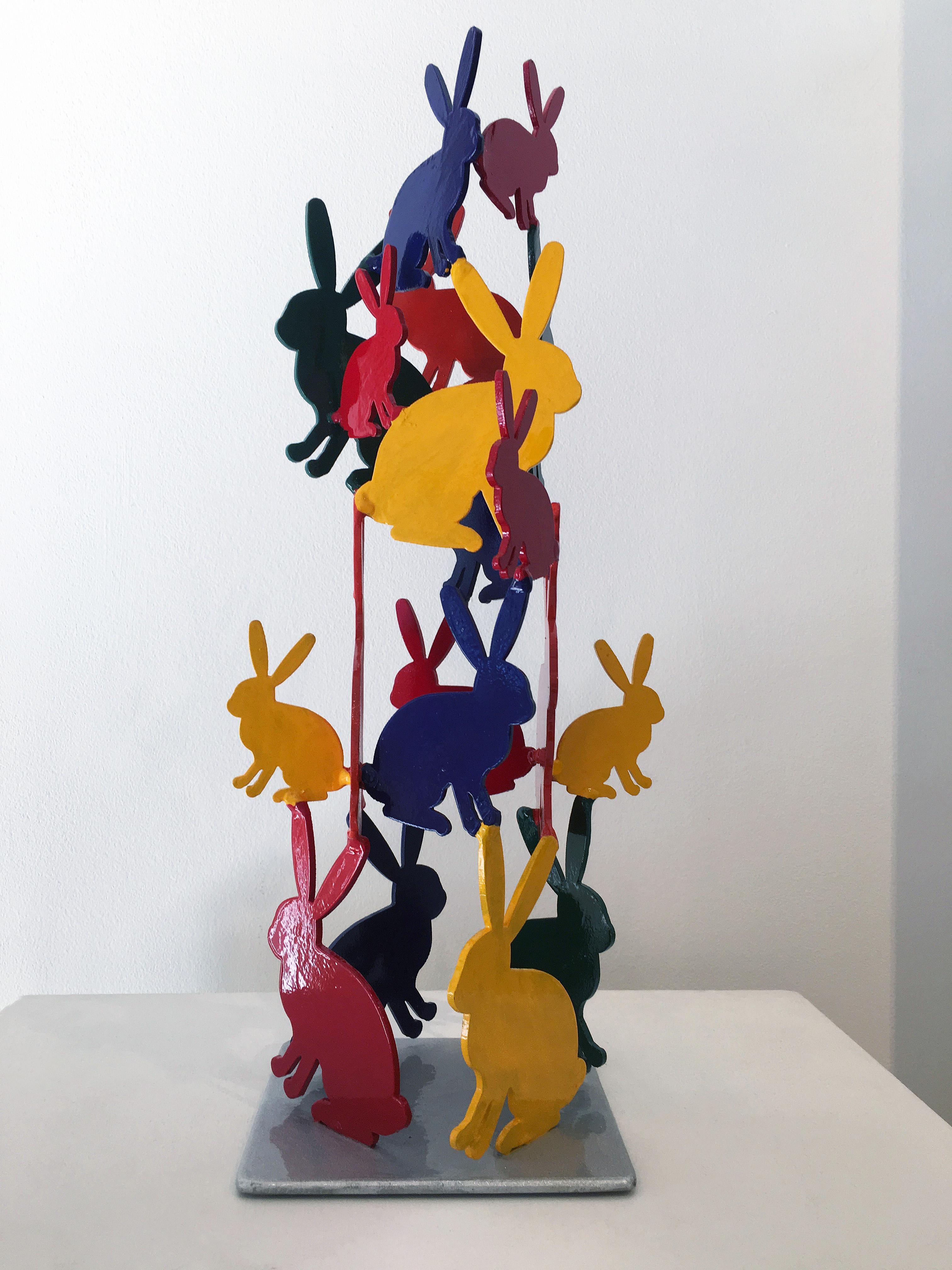'Untitled' 2019 by renowned New York City artist, Hunt Slonem. Acrylic on aluminum, 18 x 6 x 6 in. This aluminum sculpture features a plethora of cut-out bunnies in a variety of sizes on a metal plate stand. The bunnies are painted in four main
