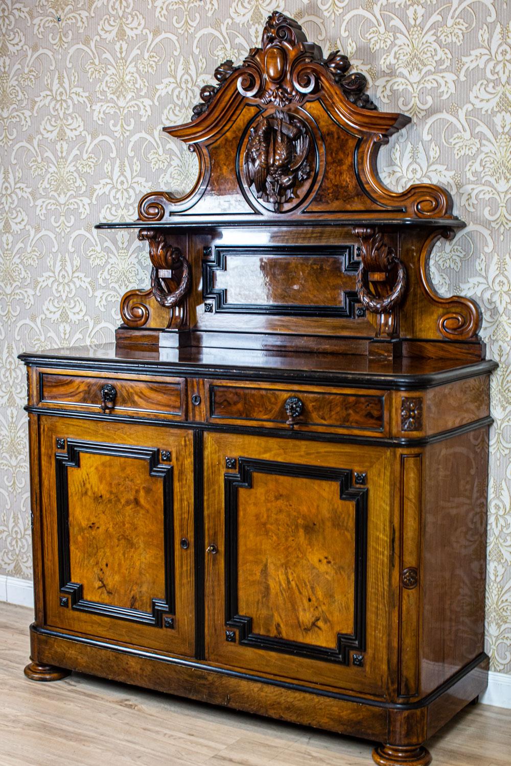 Hunter Commode from the Mid 19th Century in Walnut Veneer

We present you this piece of furniture composed of a two-leaf corpus with two drawers under the top.
The corners of the commode are rounded and decorated with carved elements.
The add-on