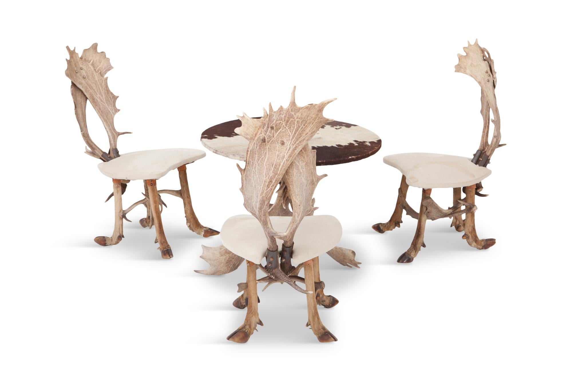 Mid-century Hunting chairs and matching centre table. The back of the chairs are made of two deer antlers while the legs are constructed out of deer hooves. The seats are upholstered in a light neutral velvet upholstery. The matching round centre