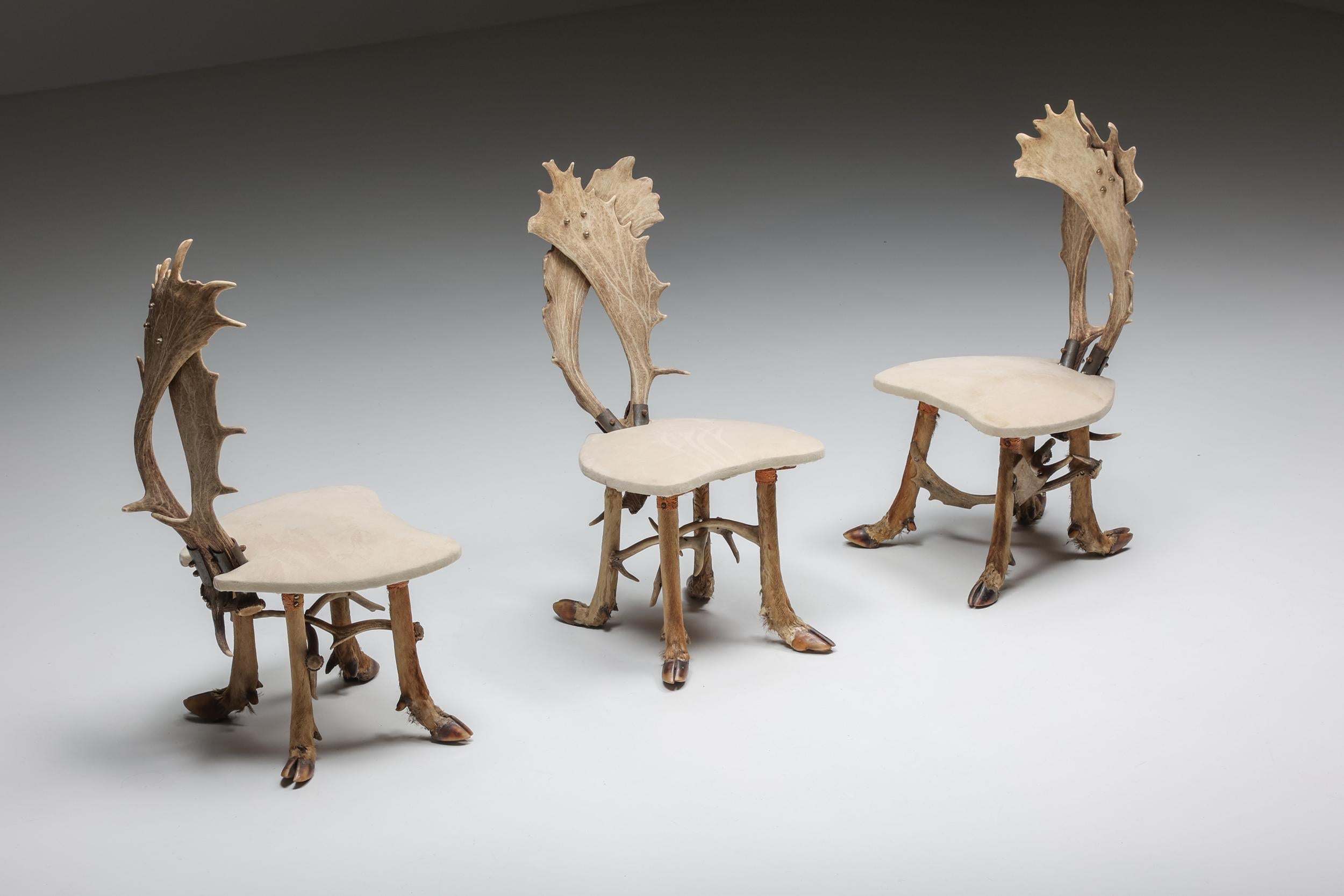 Set of hunting chairs and matching table - 1950s

Mid-century hunting chairs set of three made in the 1950s in Sweden. The back of the chairs are made of two deer antlers while the legs are constructed out of deer hooves. The seats are upholstered