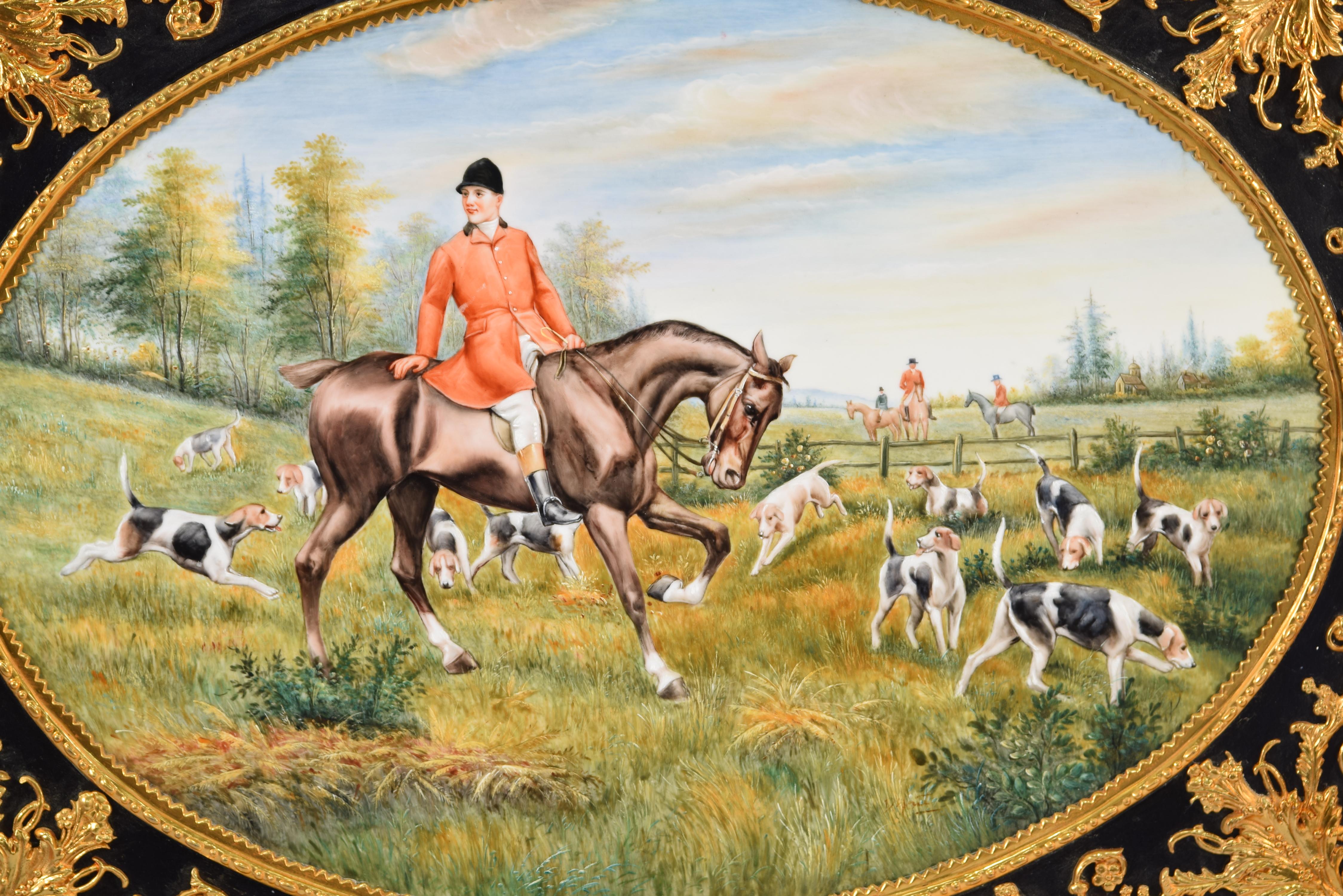 Hunting scene. Oil on porcelain. following KPM models. 
 Oil-painted porcelain plate showing a hunting scene with horsemen and dogs, enhanced by an elaborate frame decorated with elements of marked classicist influence, inspired by works from the