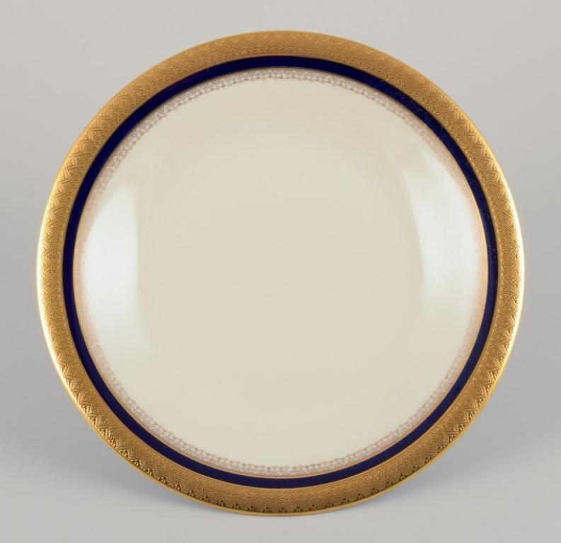 Hutschenreuther, Deutschland. Acht Essteller aus der Serie „Margarete“. Handdekoration mit Gold und Königsblau.
1930er/40er Jahre.
Markiert.
In perfektem Zustand, scheinbar unbenutzt und ohne Gebrauchsspuren.
Hutschenreuther ist ein deutscher