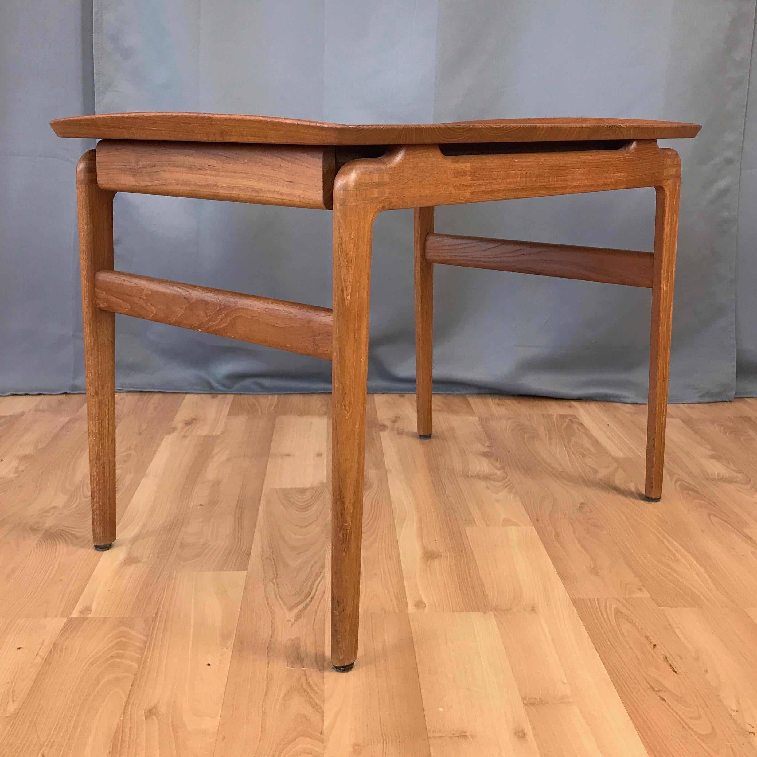 A rare late 1950s solid teak side or end table with drawer by Peter Hvidt and Orla Mølgaard-Nelson for France & Søn.

Timeless Danish modern style with expert craftsmanship on display throughout. Top with beveled edges and lipped ends floats on a