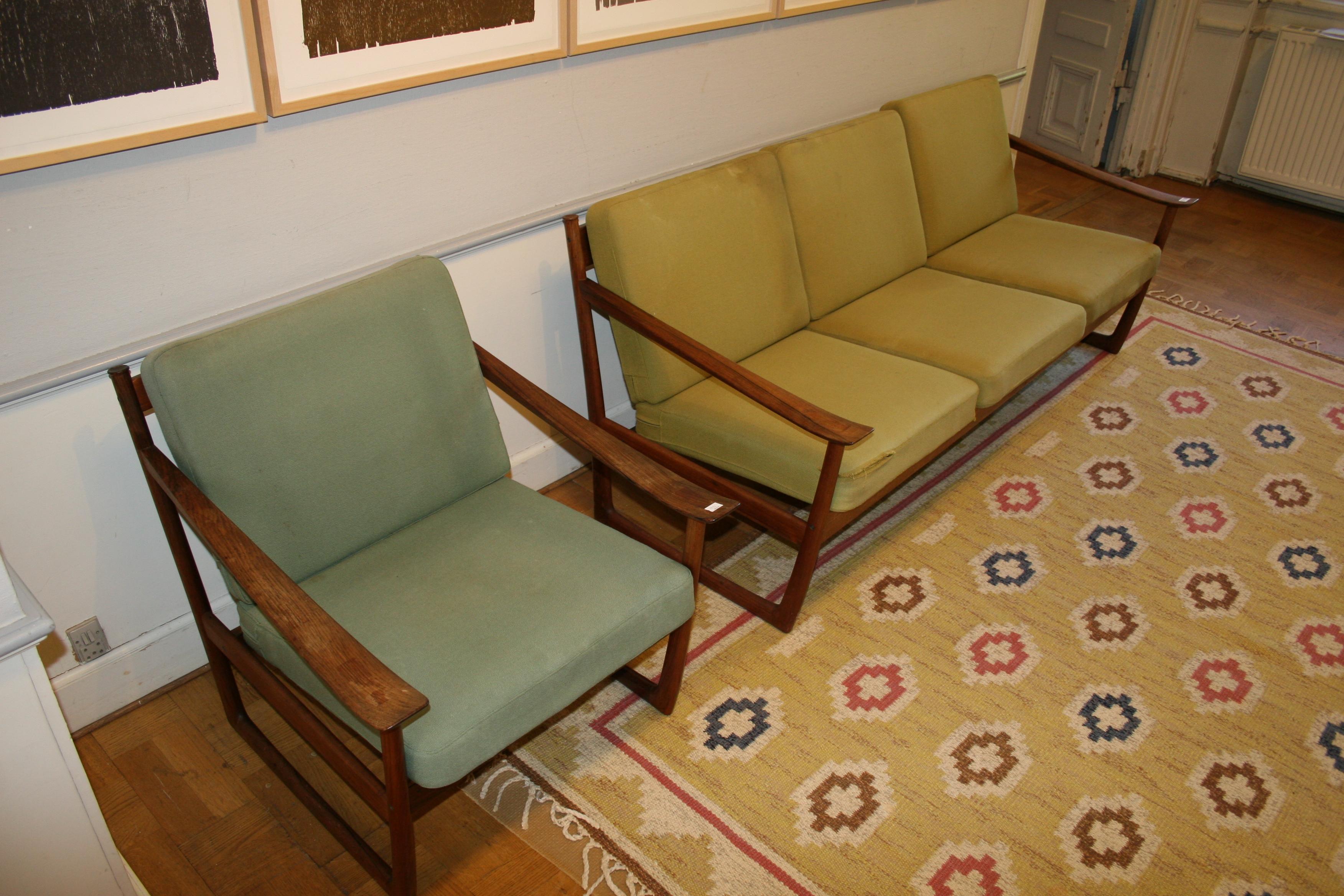 Freestanding three seater sofa and matching easy chair of rosewood. Loose cushions in seat and back upholstered with two different shades of green wool. Model 130. Designed 1961. These examples manufactured 1960s by France & Søn, with maker's metal