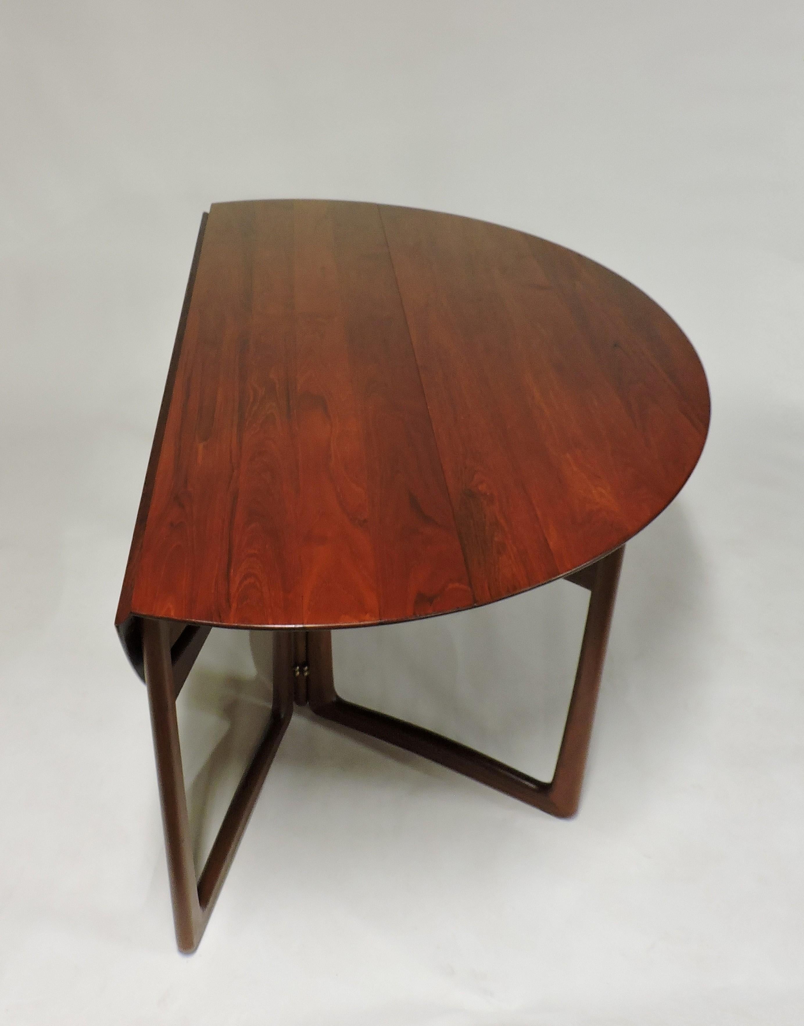Beautiful and practical drop-leaf dining table designed by Peter Hvidt and Orla Molgaard-Nielsen. This was made in Denmark by France and Daverkosen, and sold through high-end retailer, John Stuart. The solid teak has a deep, rich color and a lively