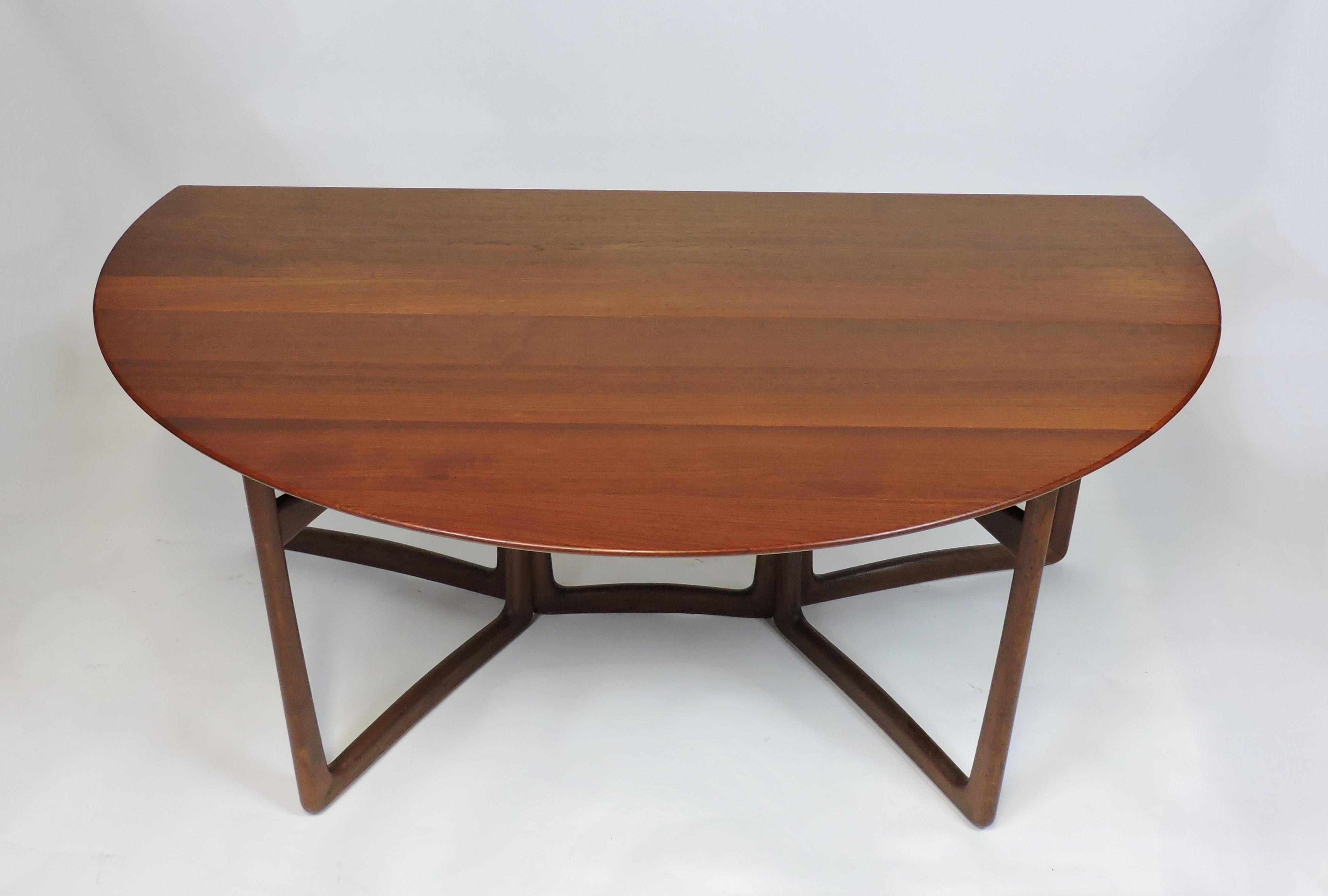 Beautiful and practical drop-leaf dining table designed by Peter Hvidt and Orla Molgaard-Nielsen. This was made in Denmark by France and Son and sold through high-end retailer, John Stuart. The top and the sculpted legs are made of solid teak which