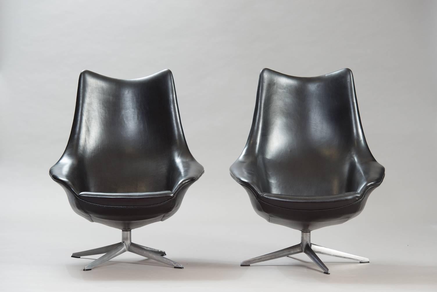 Pair of swivel lounge chairs “Pirouette” model, aluminium base, upholstered in black faux leather.