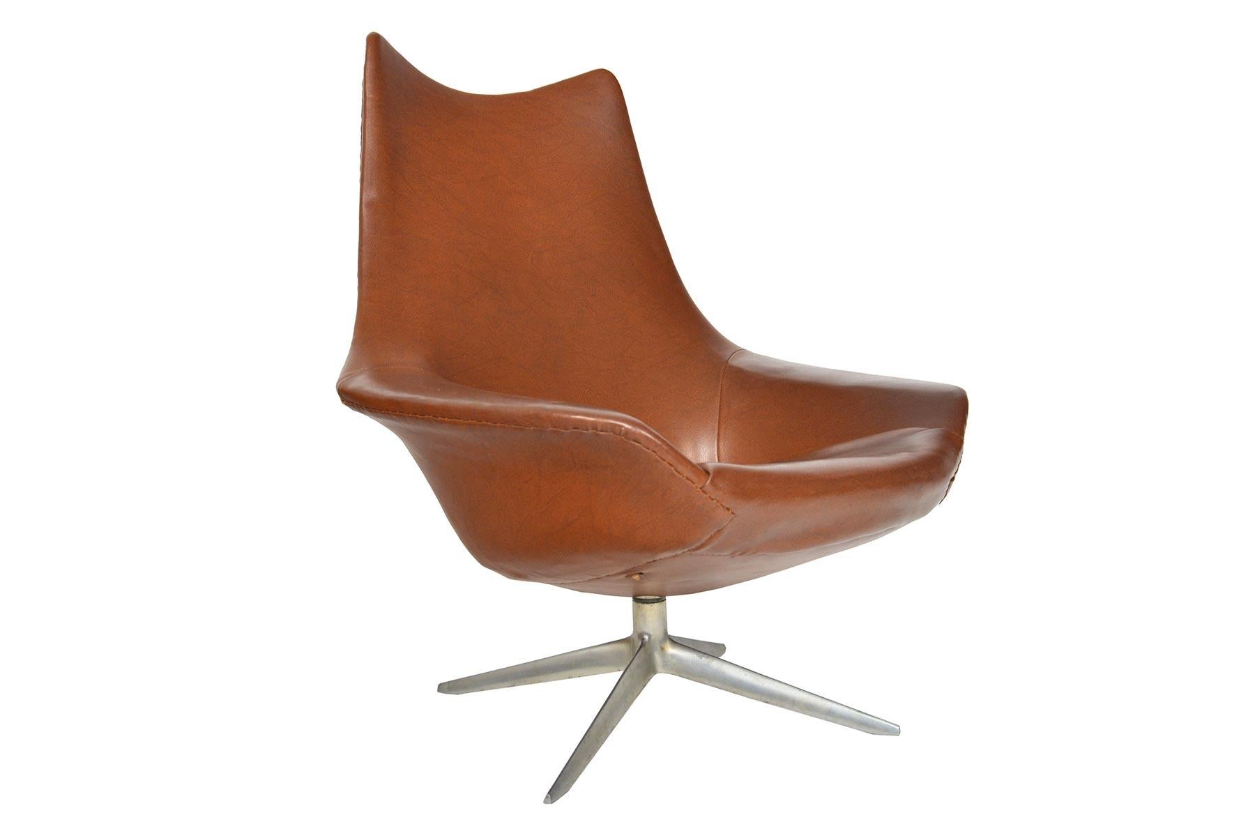 This Space Age swivel chair was designed as Model 208 'Pirouette' by H.W. Klein for N.A. Jørgensens Møbelfabrik in the 1960s. With a sleek, organic form, this brown vinyl lounge chair is upholstered on all sides. The swivel base offers 360° of