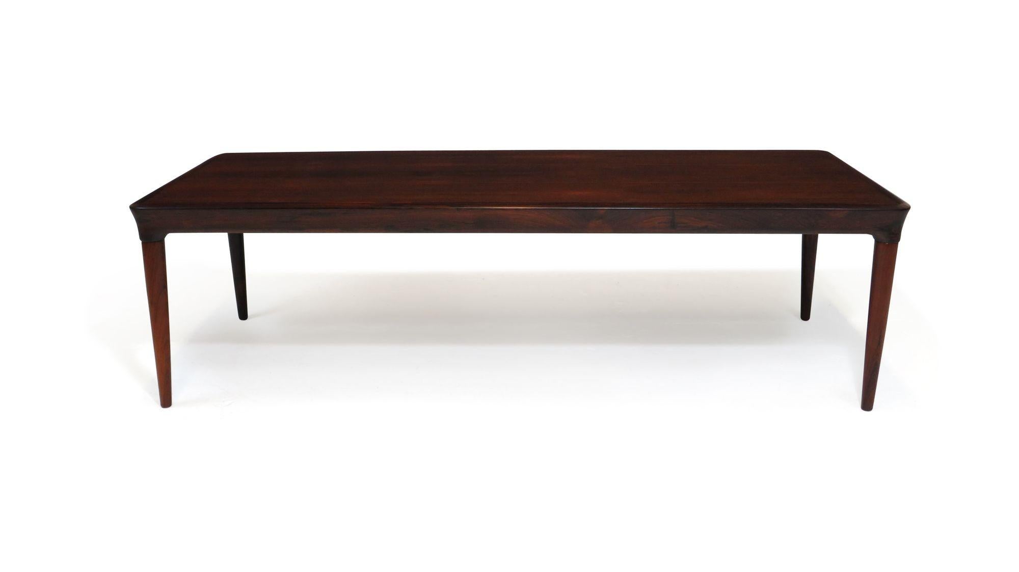 Mid century rosewood coffee table designed by H.W Klein, 1955, Denmark. The coffee table is crafted of Brazilian Rosewood with finely mitred edges and sculpted edges, raised on tapered legs.