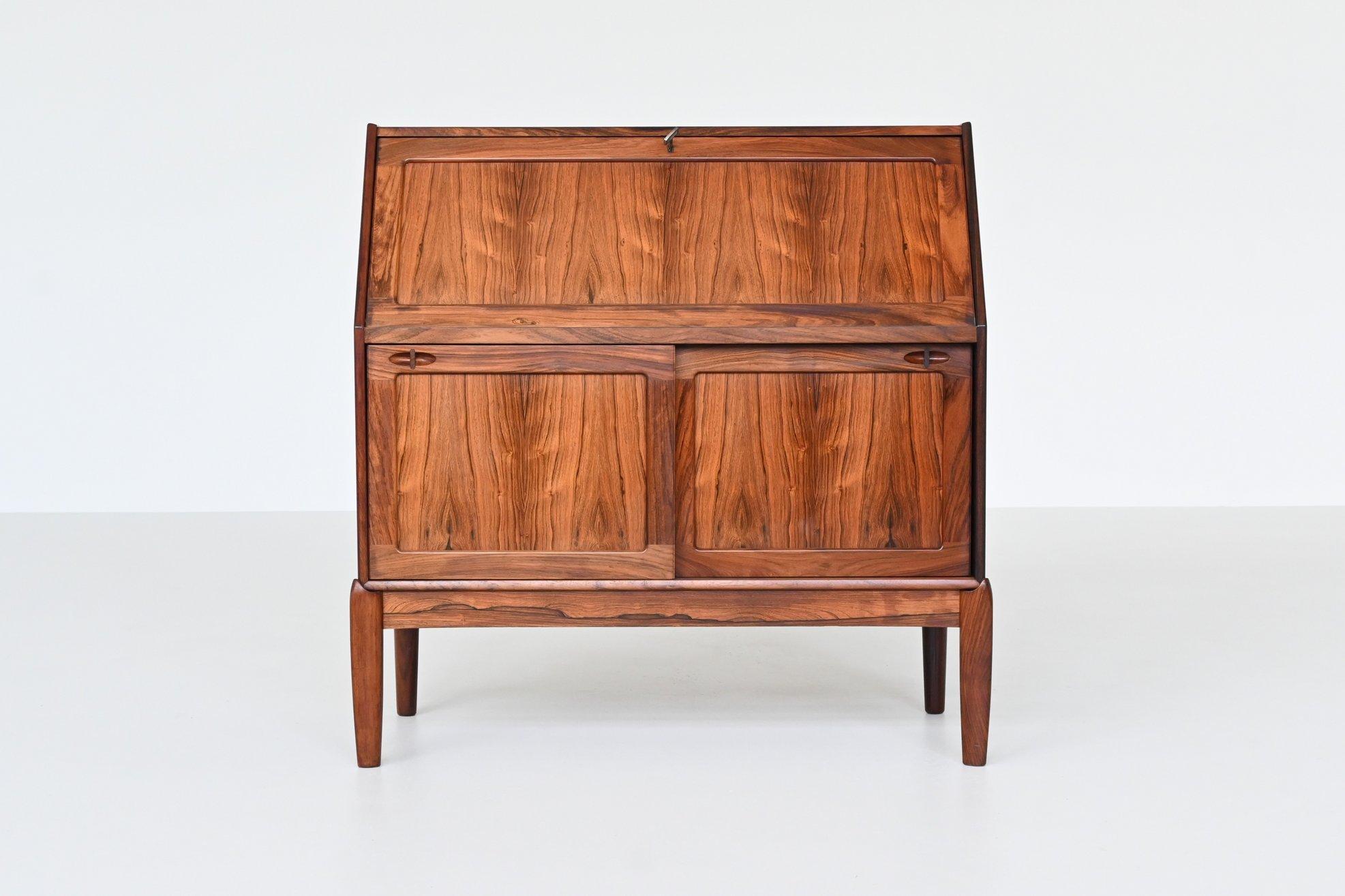 Bellissima scrivania scandinava disegnata da H. W. Klein per Bramin, Danimarca 1960. Questo bel pezzo di arredamento danese è molto funzionale grazie alle numerose opzioni di archiviazione e all'utilizzo come scrivania. È realizzato in noce con una