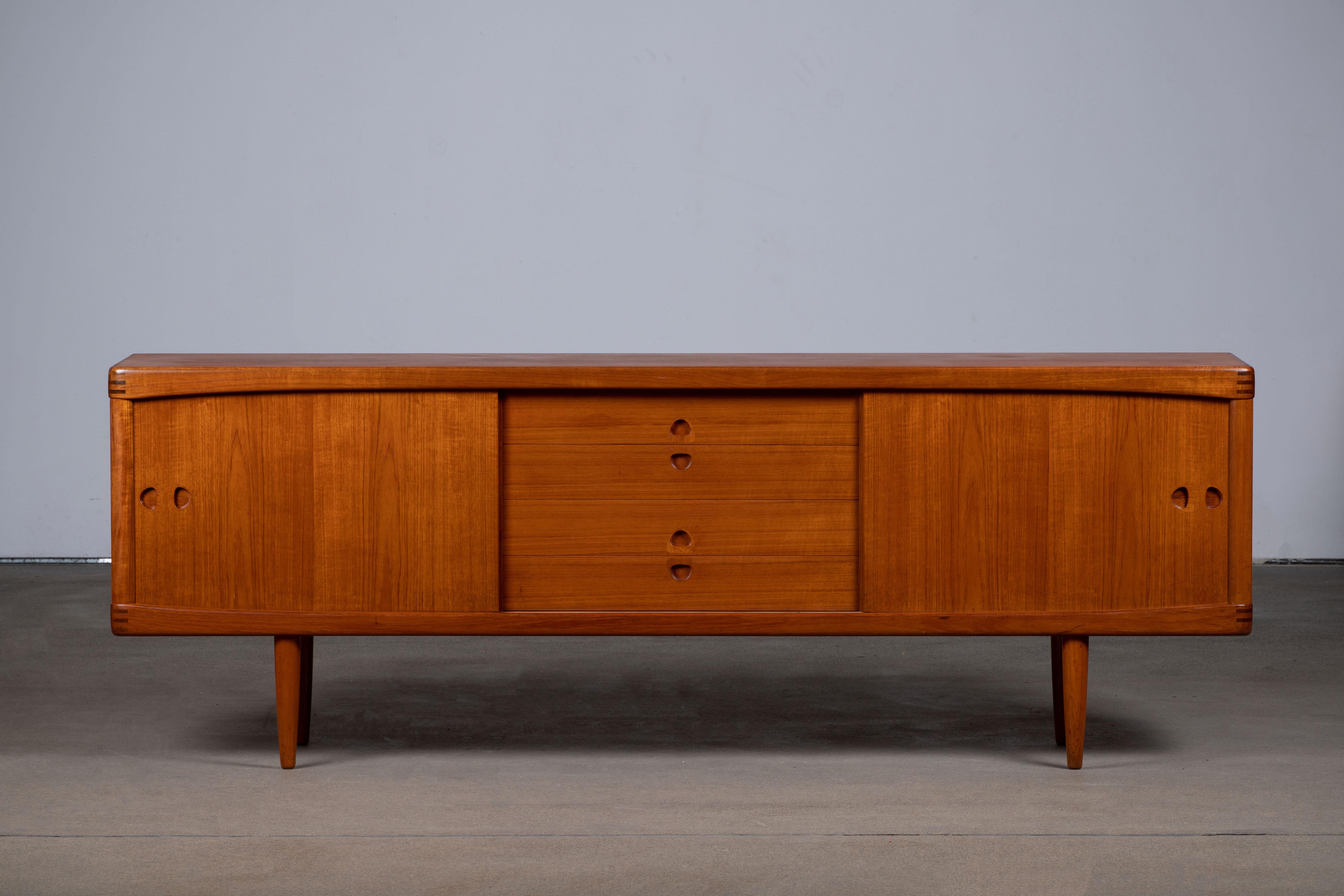 Stunning midcentury designed by Henri Walter Klein teak sideboard by Bramin Møbler, 1960s, lovely top and sliding doors, fully lined drawers and stands on nice solid teak legs.
Fine wood joinery at the corners.
An elegant piece.
Good condition