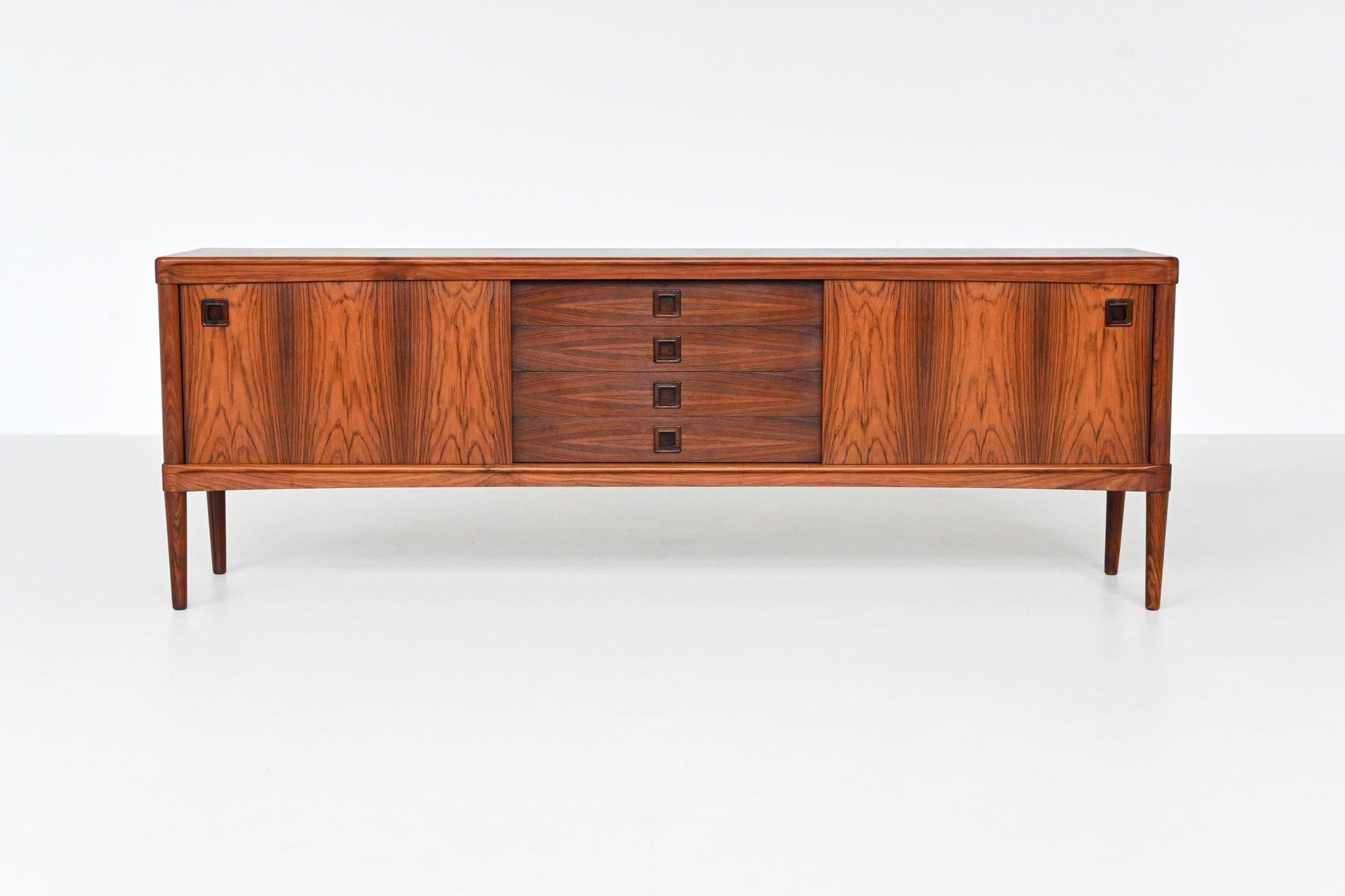 Stunning sideboard designed by Norwegian-born designer Henry Walter Klein for the Danish furniture manufacturer Bramin, Denmark 1960. This sideboard is made of beautiful grained rosewood and it has tapered solid legs. With four central drawers