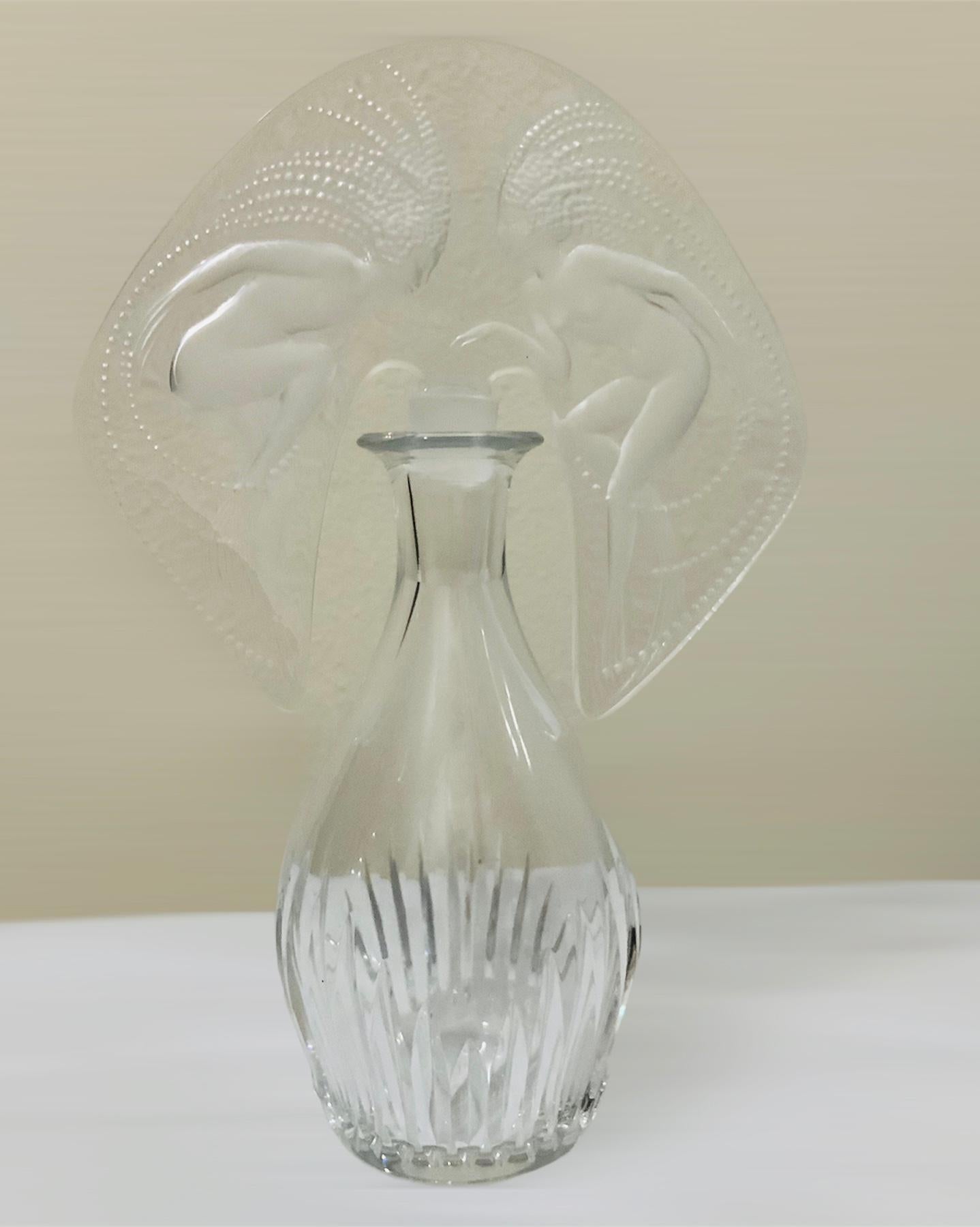 This is a hybrid perfume bottle with a Lalique “Ondines” stopper and Baccarat “Massena” bottle. The stopper is adorned with a pair of water nymphs and is marked with the numbers-507. The Baccarat bottle is clear and it is ribbed at the lower body