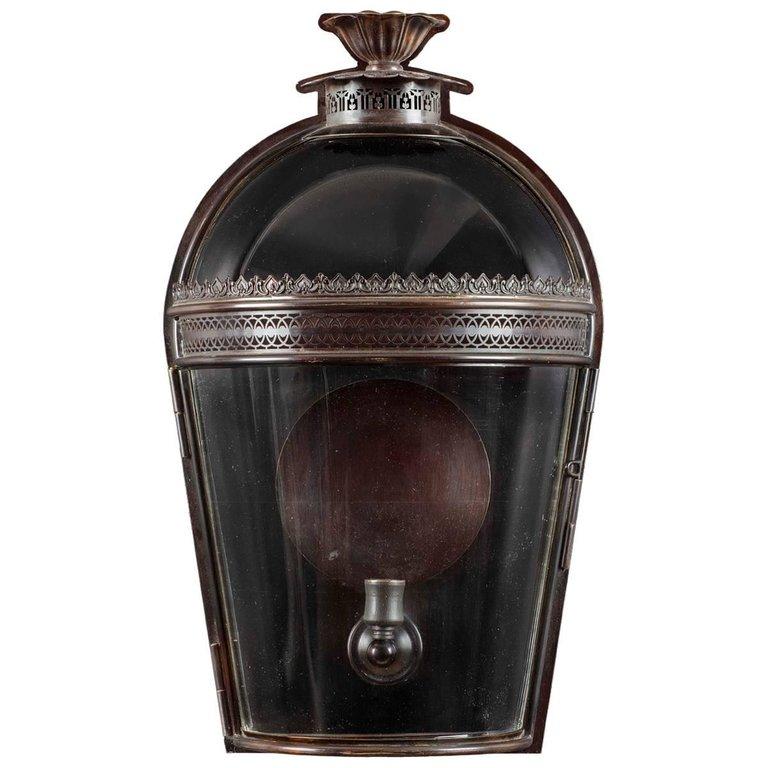 The graceful arched and glazed top with the petal shaped smoke outlet above the pierced filigree work and tapered sides makes this wall lantern both elegant and functional. 