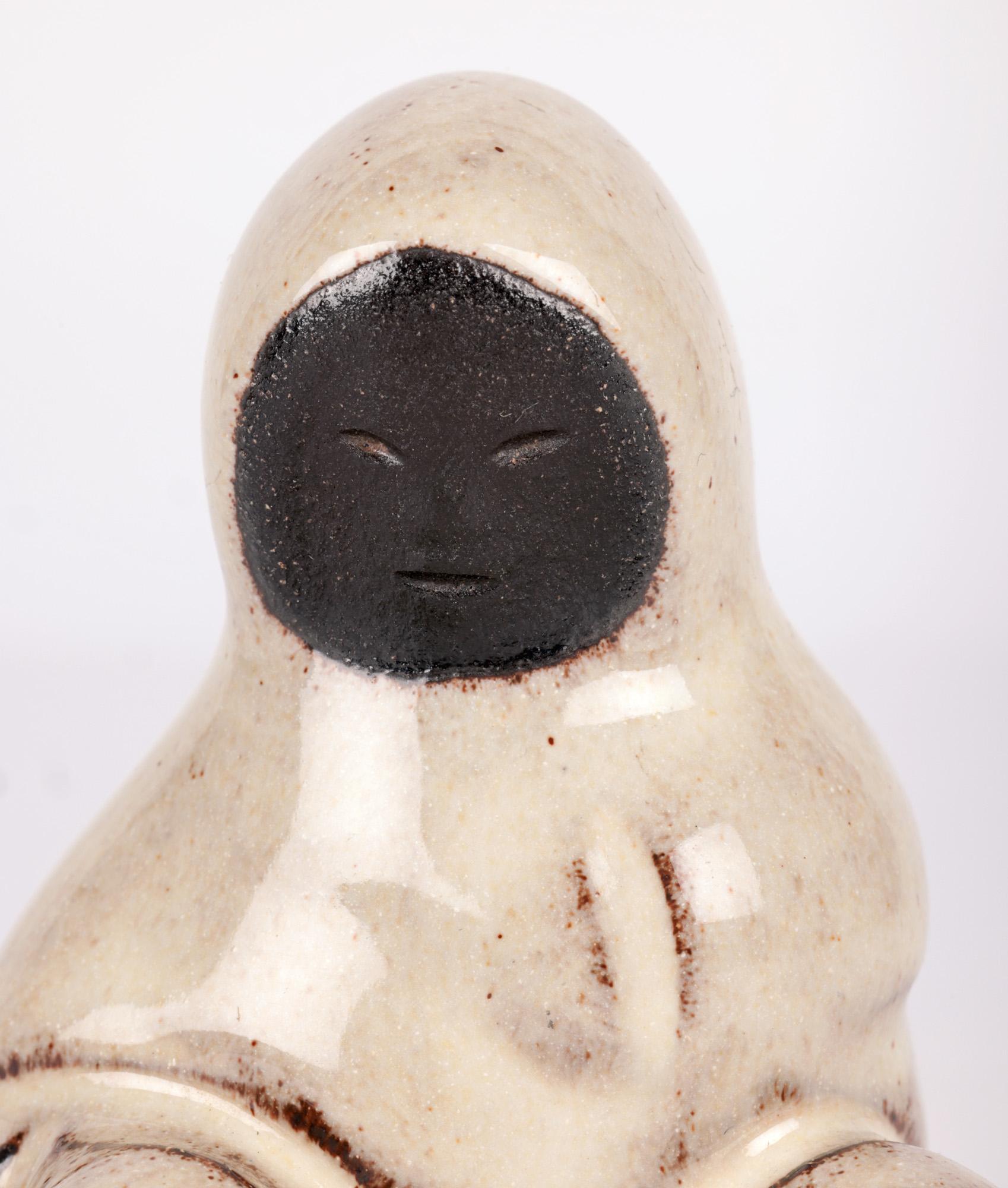 A charming and uncommon Danish mid-century art pottery eskimo figure made by Hyllested Keramik and dating from around 1960. This highly collectable figure is referenced by some as representing a Greenland eskimo and others as Inuit and the black