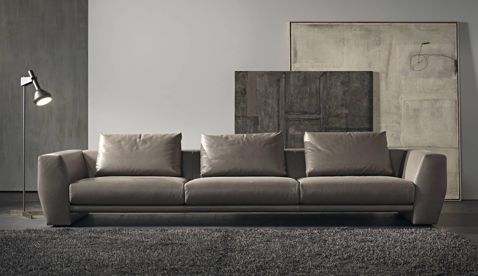 A sofa with a special bridge structure, slender and linear, that reveals and enhances the decisive forms and the pronounced volumes of the weight-bearing arms, giving an unusual shape to comfort, strictly in leather. The low back creates an unusual