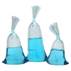 Hyperreal blue glass water bag trio sculpture installation