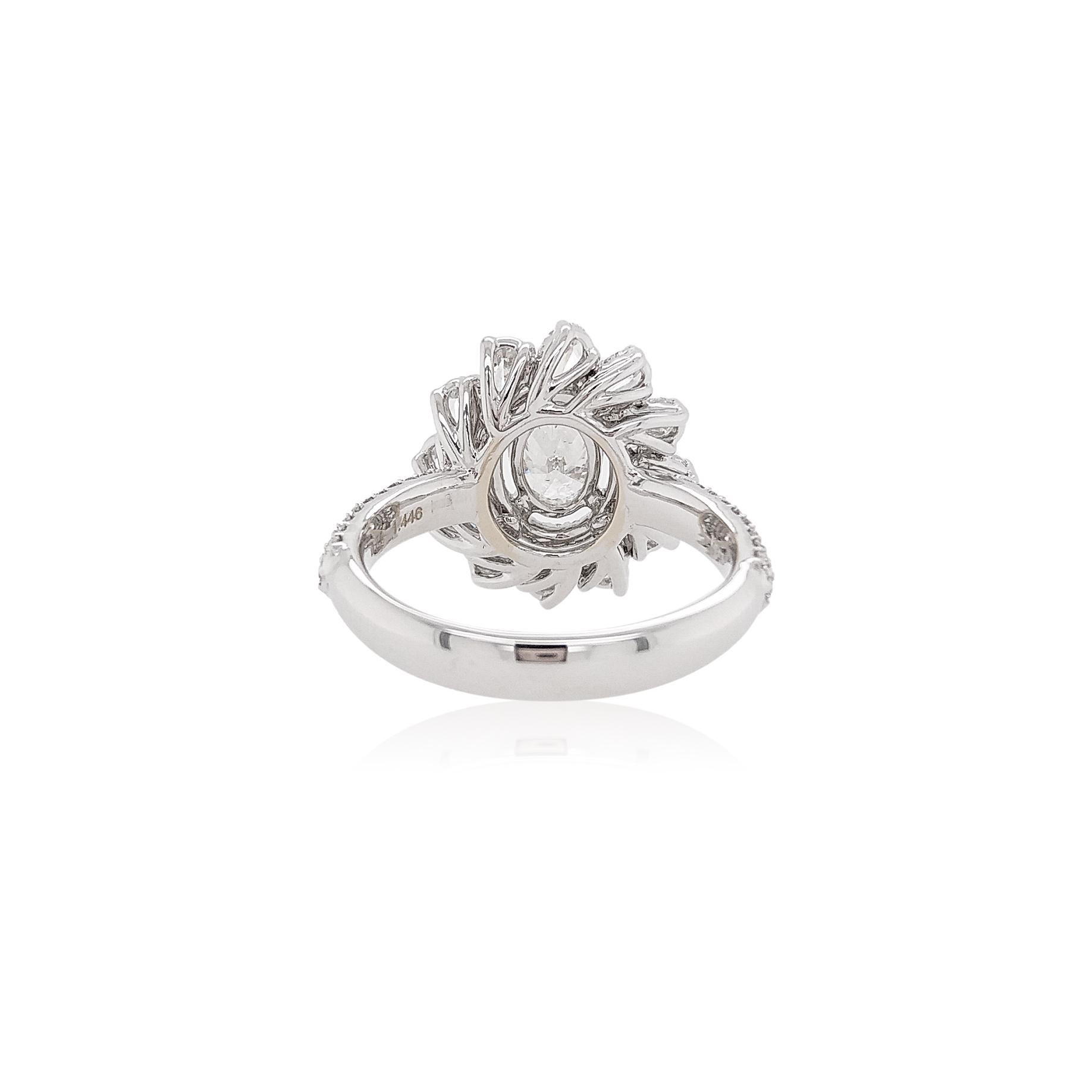 This striking 18K White Gold ring is both unique and elegant. At the forefront of this piece is a vibrant GIA-certified Oval shape White Diamond. The lustrous of the diamond is complimented perfectly by the sparkle of the diamonds which surround it.