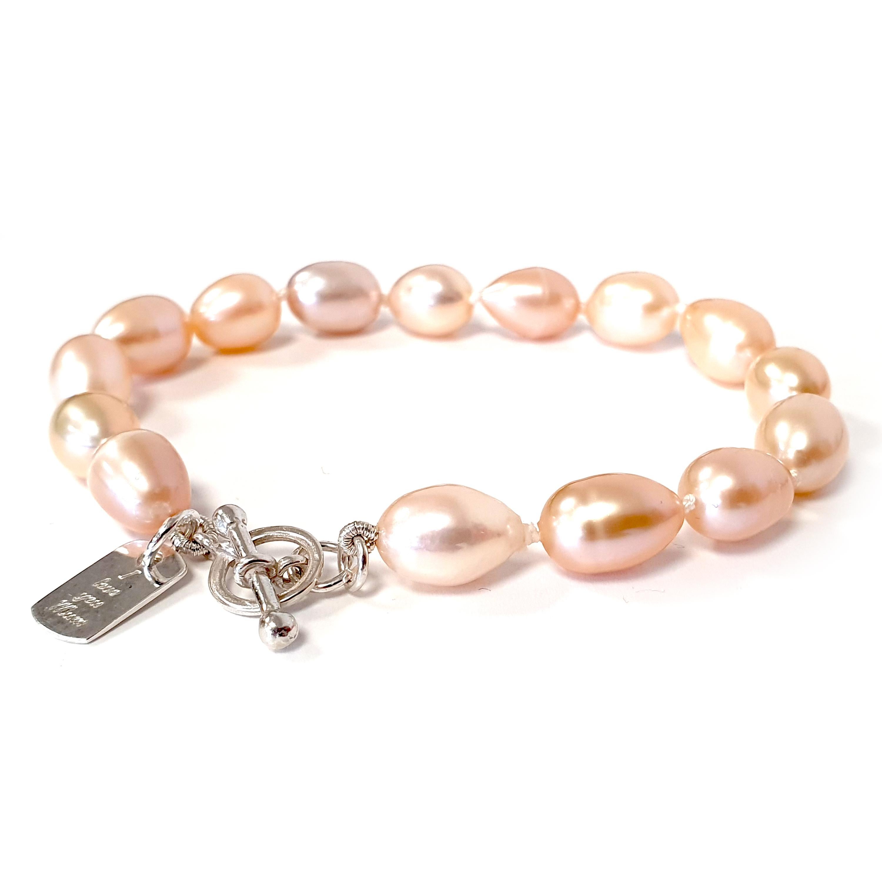 A single-strand knotted pearl bracelet perfect for everyday wear. A beautiful arrangement of pinky-peach freshwater pearls with a sterling silver T-bar clasp and a tag engraved with 