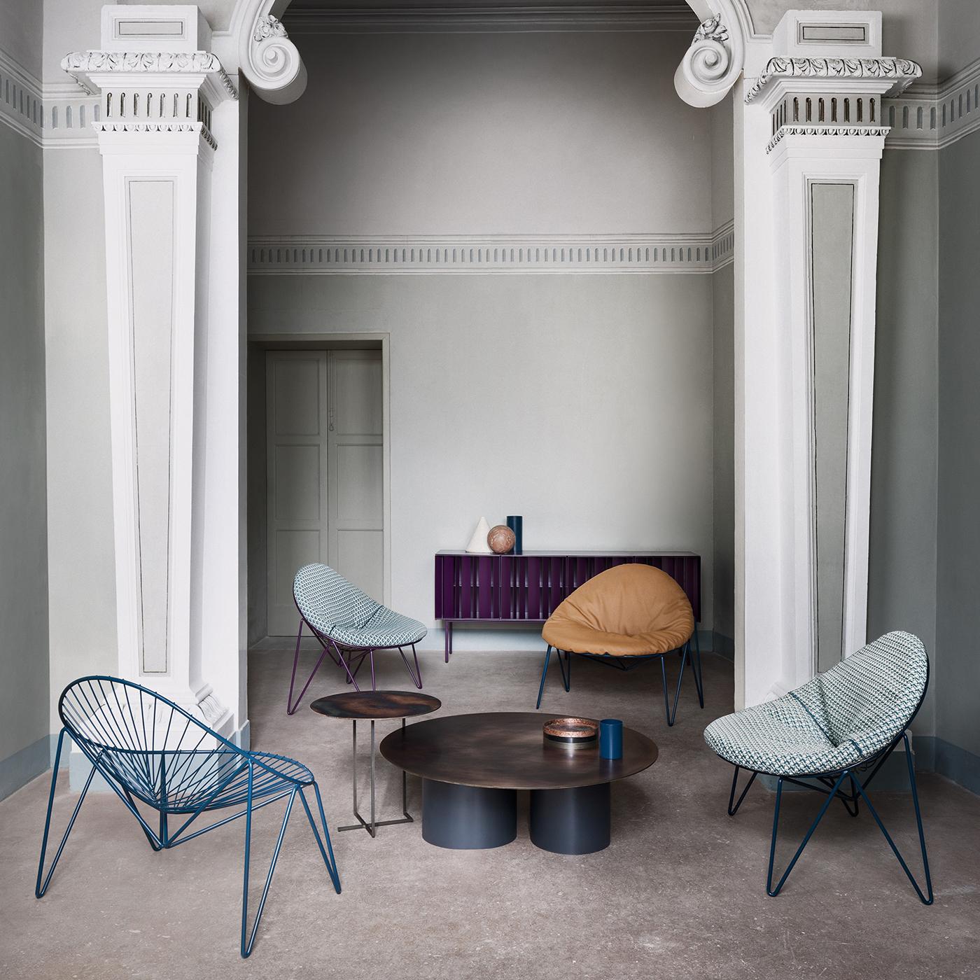 Les deux éléments cylindriques qui soutiennent le grand plateau rond sont des éléments distinctifs de cette splendide table basse. Fabriquée en acier, la base présente une couleur noire mate et lisse, tandis que le dessus arbore une finition en