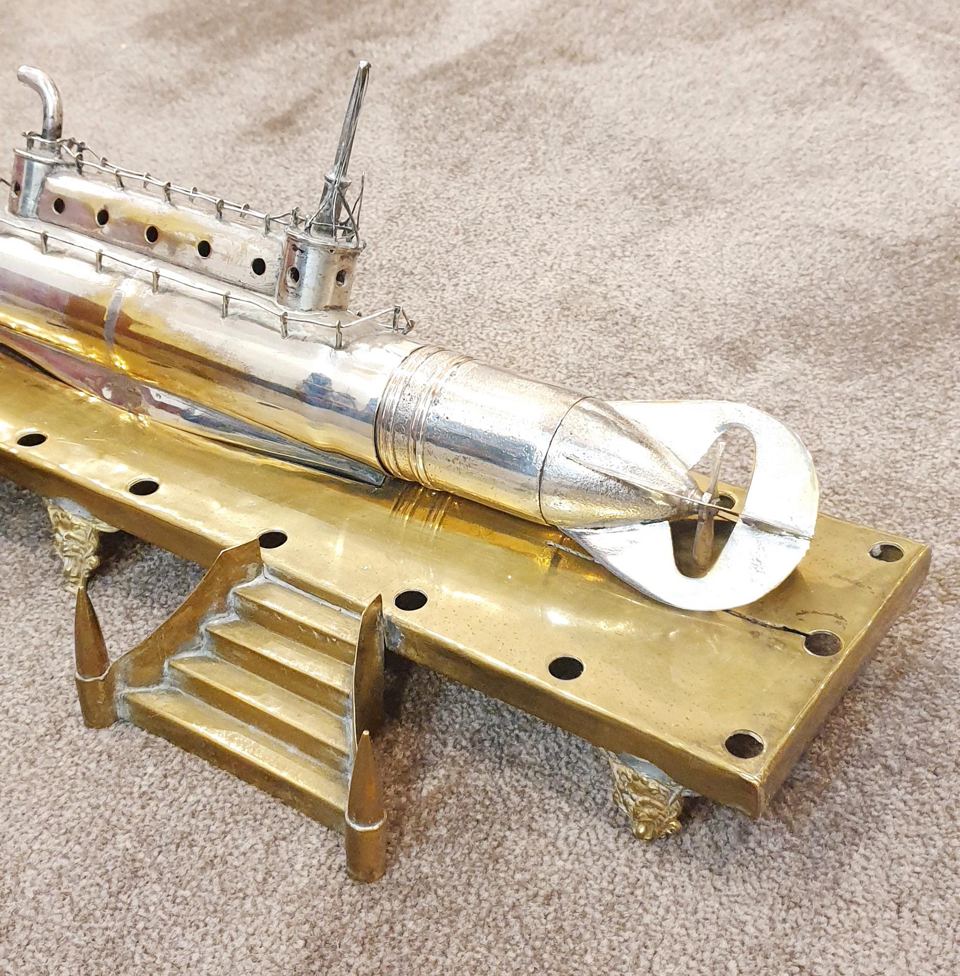 World War I Submarine mounted on Brass. 
The sub has been built from bullets and other pieces of brass to form an exceptional piece. 
This is a lovely item measuring approx: 
LENGTH platform : 43cm Length Submarine 39cm  // 16,92 x 15,35 inches
