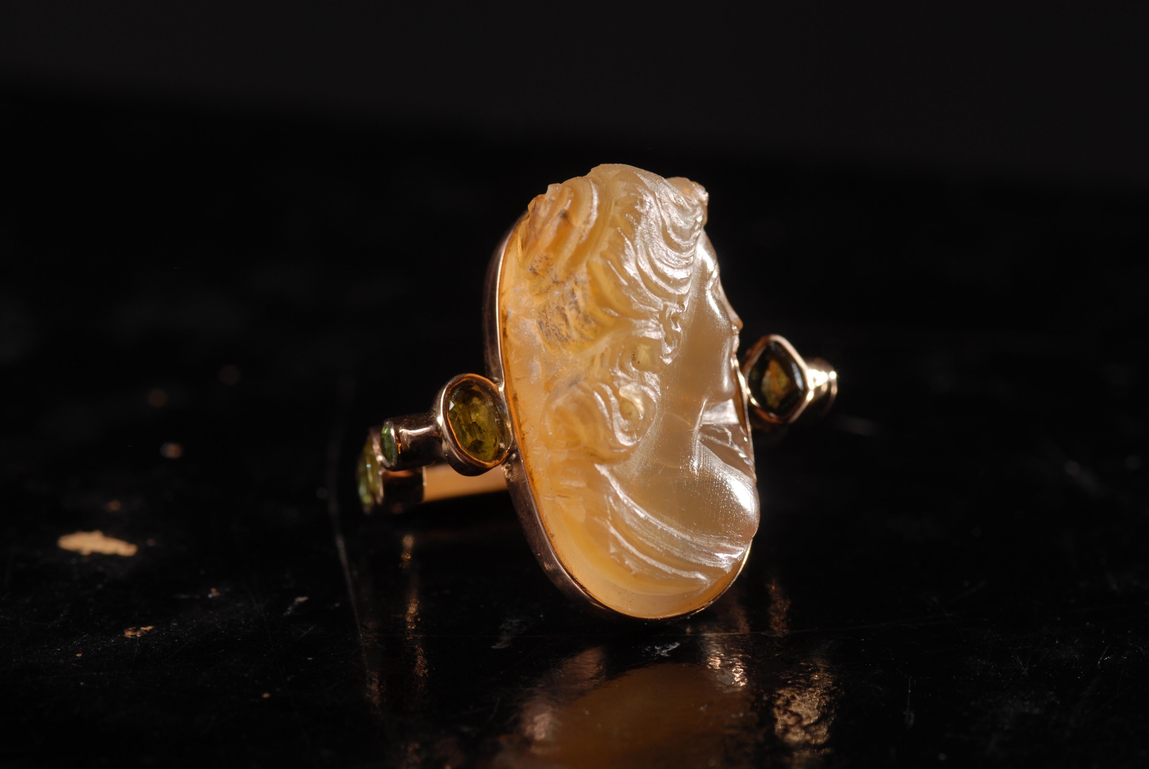 14- carat gold contemporary rectangular unusual cocktail ring with a relief, cameo on the semi-transclusent dark cornelian. The sides of the ring are adorned with dark tourmalines and sapphires. Recommended for the index finger. 

Size N (US 7)