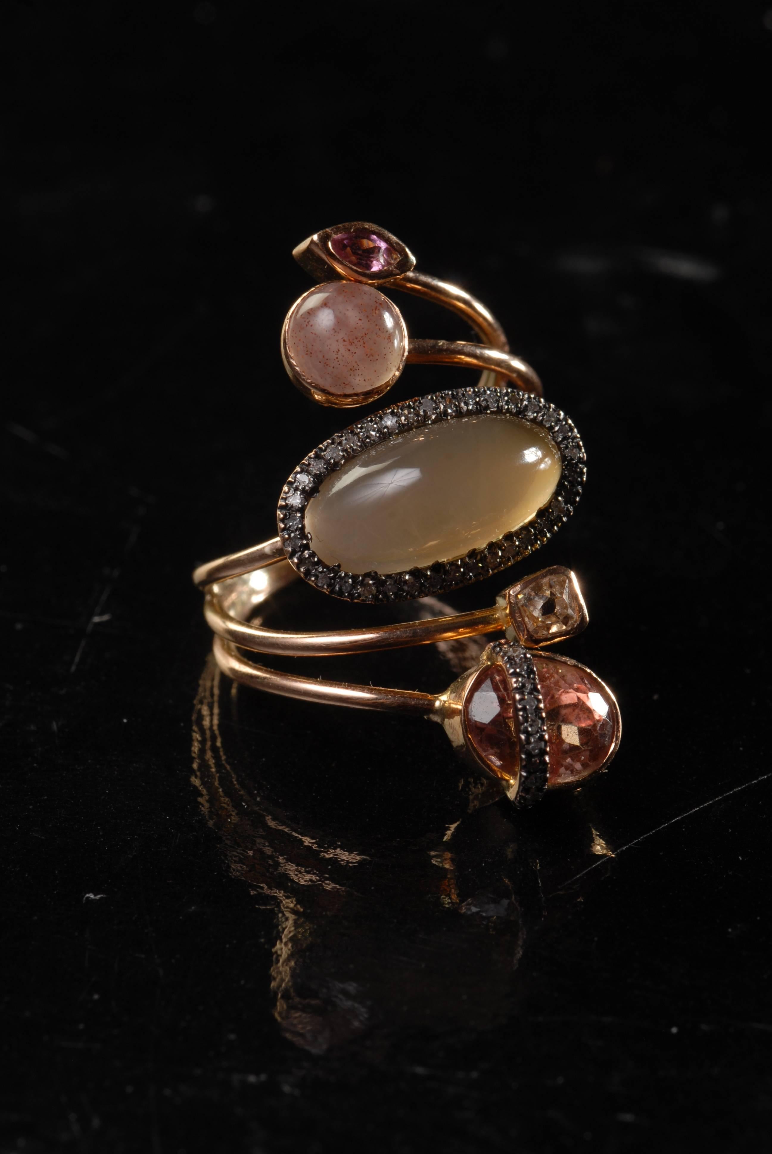 This spiral, branched handmade 14 carat rose gold ring is made with grey oval chalcedony, surrounded by small diamonds, round rose chalcedony, oval rose sapphire with a band of small diamonds on top and small square colored diamond and marquise-cut