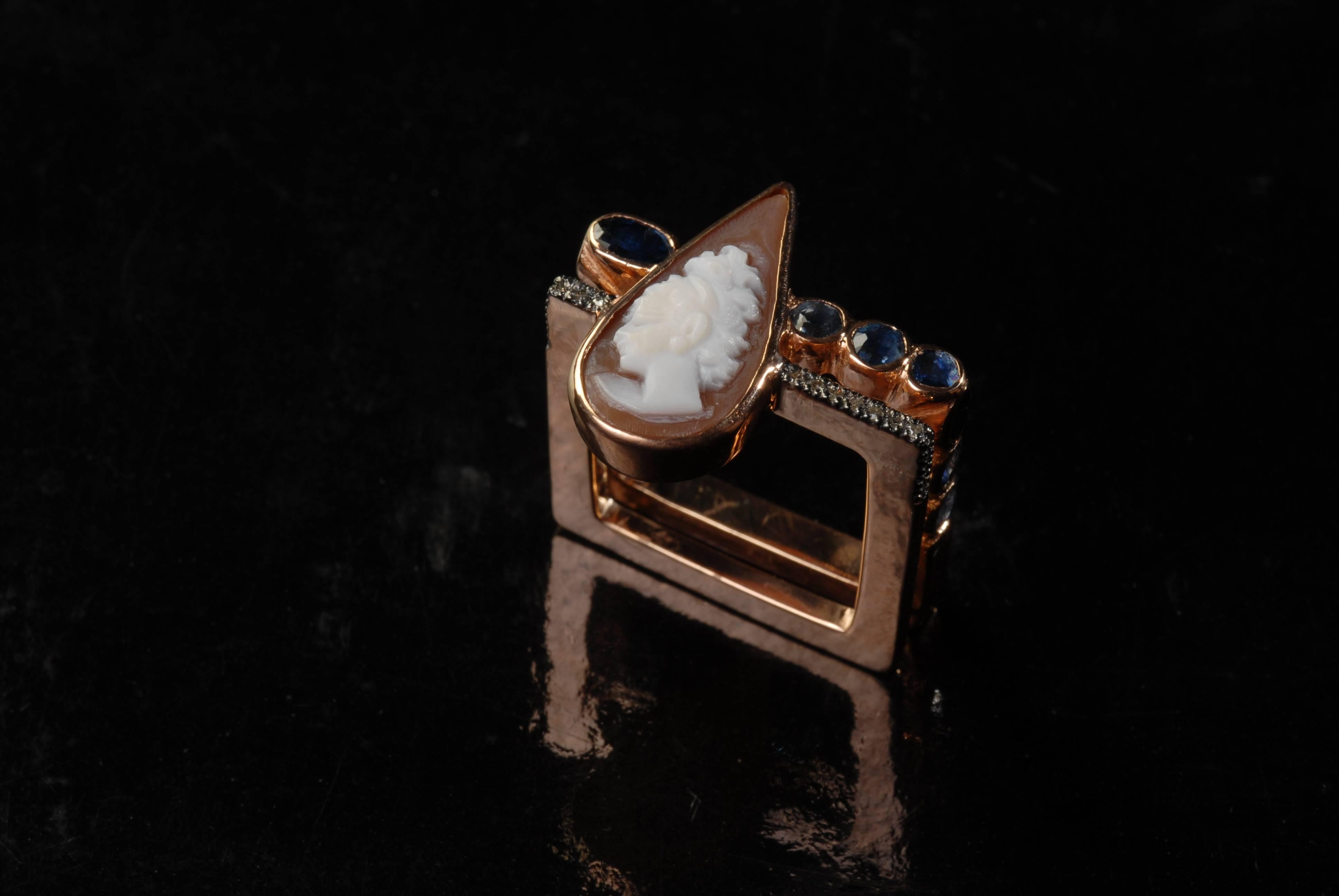 This handmade, rose color, gold plated silver square ring has a vintage teardrop cameo on the shell, different shaped blue sapphires, and  small diamonds. Gorgeous on the index finger. 

Ring Size US 9/ UK R 