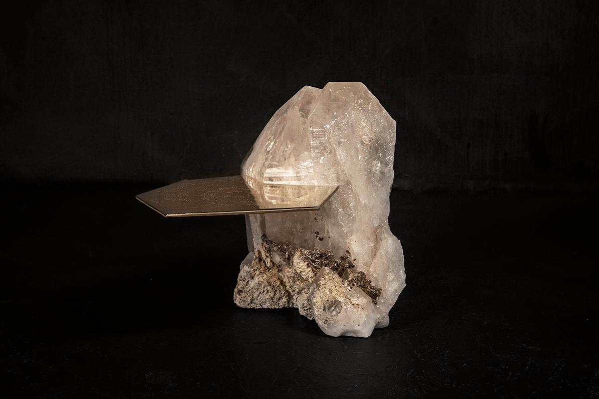 Cette table basse sculpturale transforme un rare bloc de quartz brésilien en une œuvre d'art fonctionnelle. Sélectionné à la main pour sa clarté exceptionnelle et ses formations cristallines naturelles, le quartz a été coupé en deux avec précision