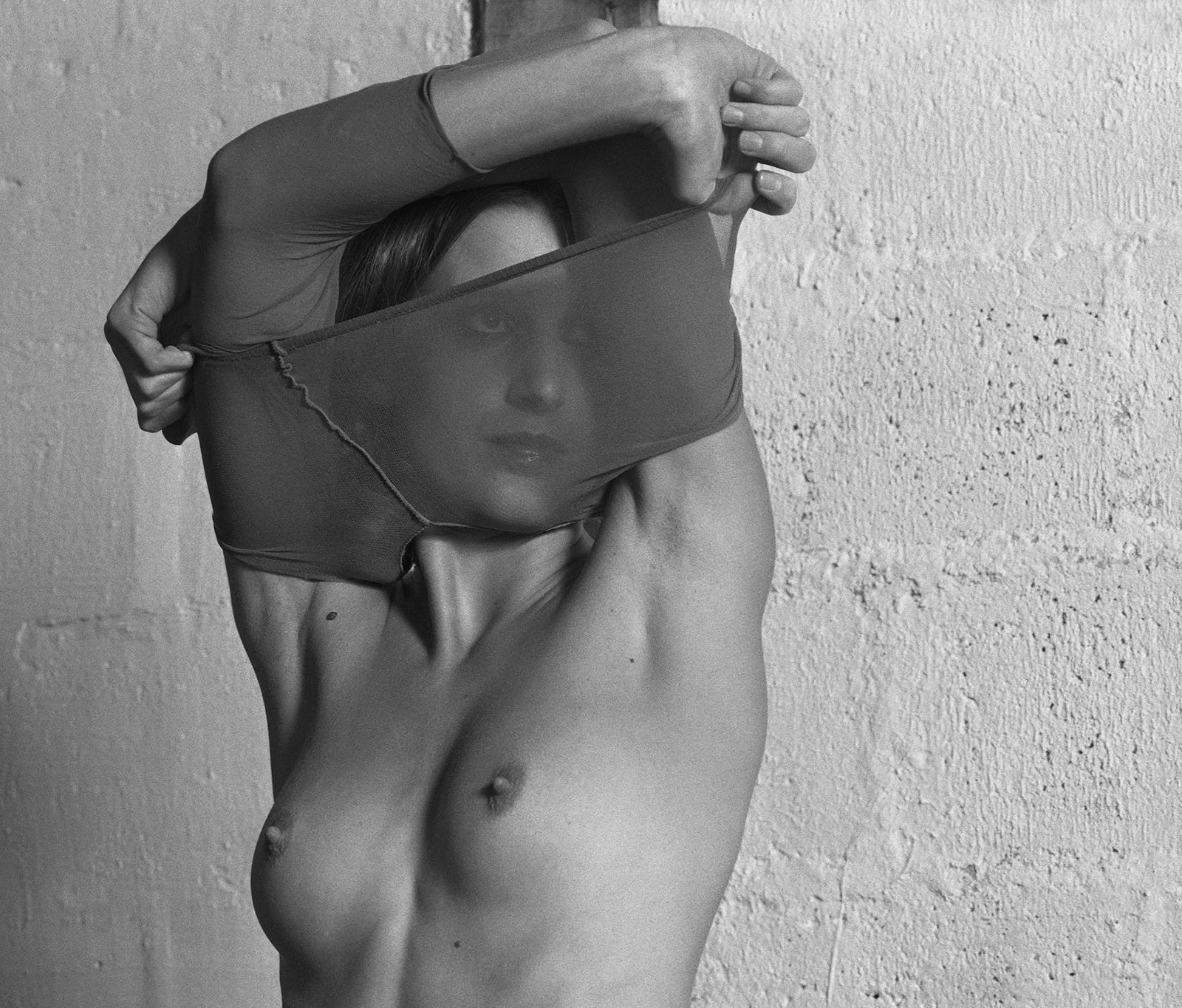 Ségolène - Sexy donna nuda che si spoglia a letto, contemporanea con uno stile vintage - Nude Photograph Grigio di Ian Sanderson