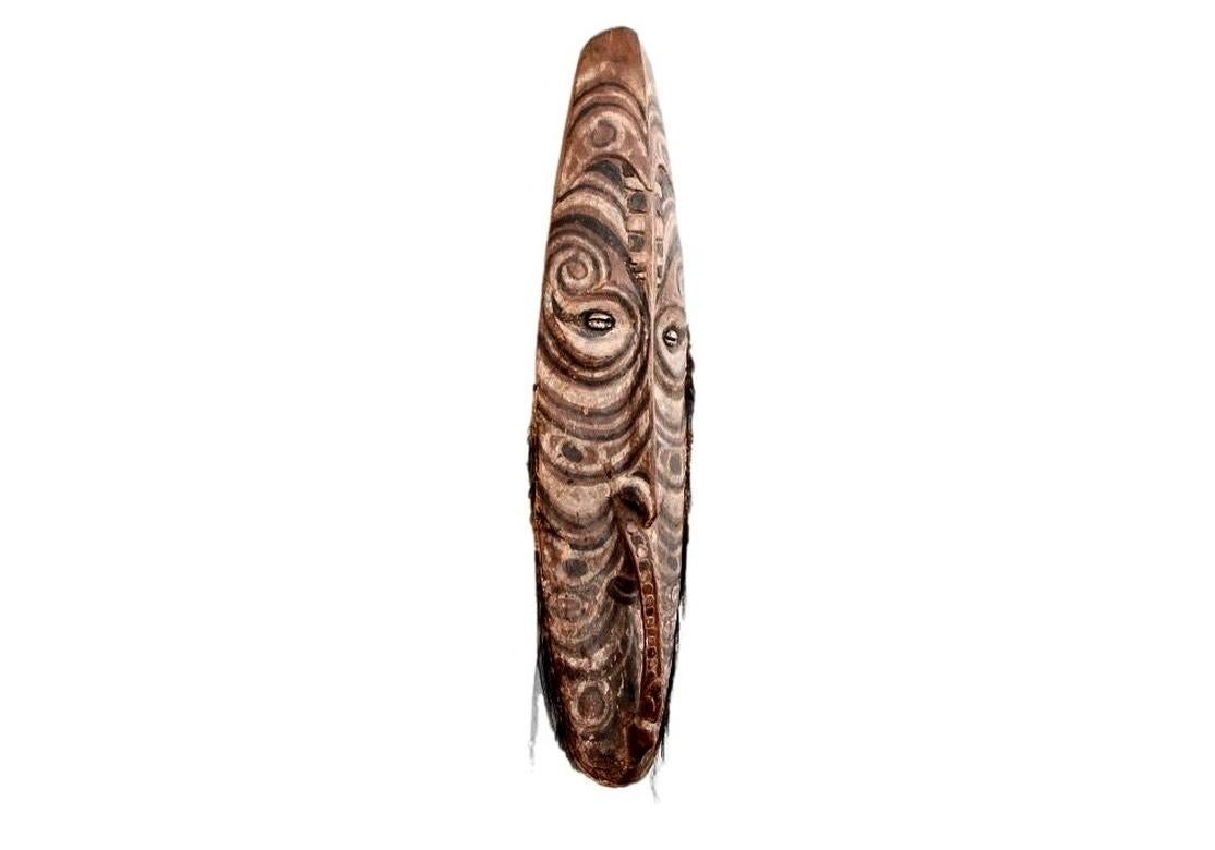 A large and powerfully carved Ceremonial Mask from New Guinea. In mineral paints with Cowrie Shell Eyes. 
Collected in Kaminabit, Middle Sepik Region, Papua New Guinea.  
The Mei is the ancestral guardian of the junior grade society, but it is used