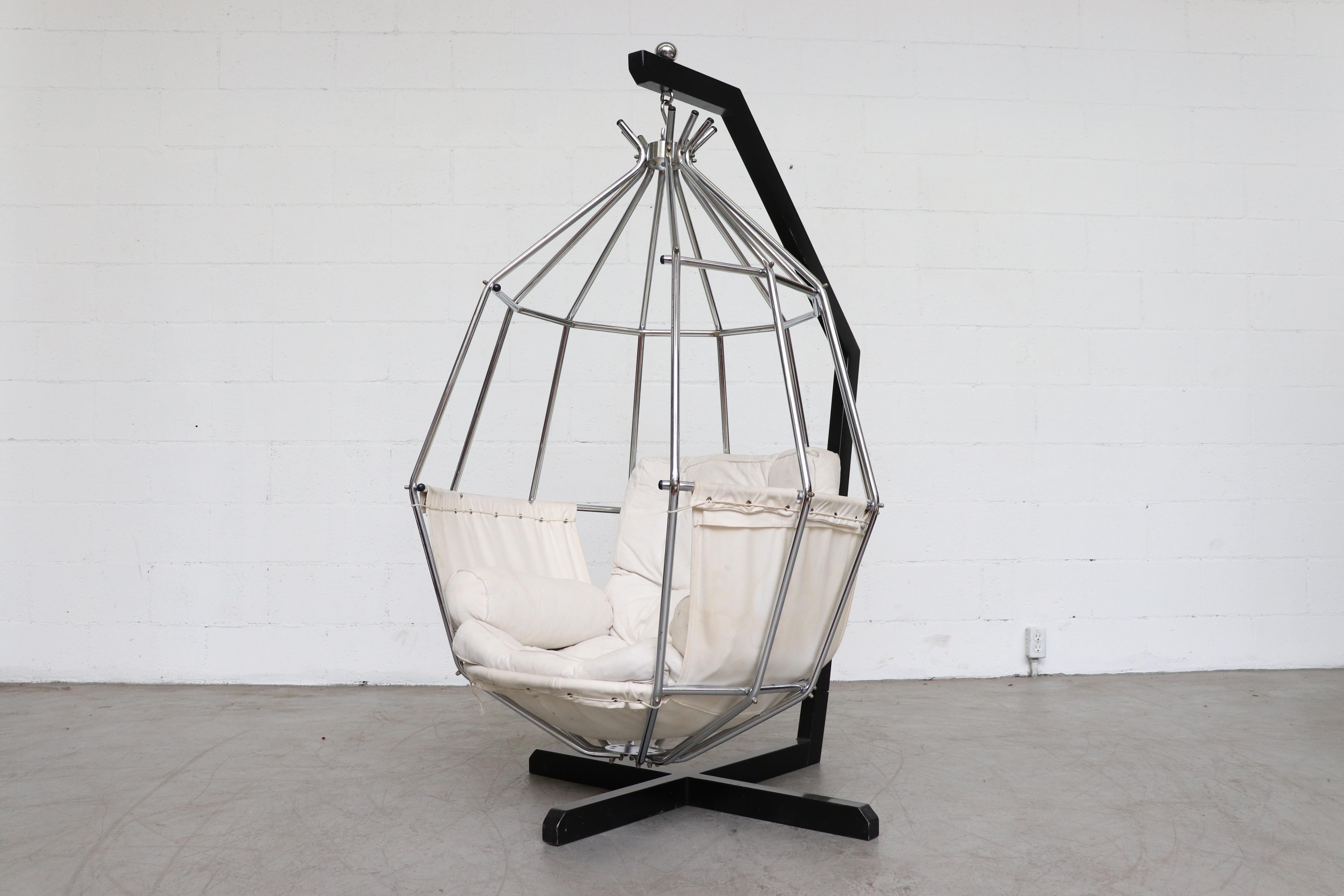 Ib Arberg 'Parrot' hanging chair. In original condition with visible signs of wear. Some staining to the canvas upholstery, and minimal denting to the metal frame. Wear is consistent with its age and usage.