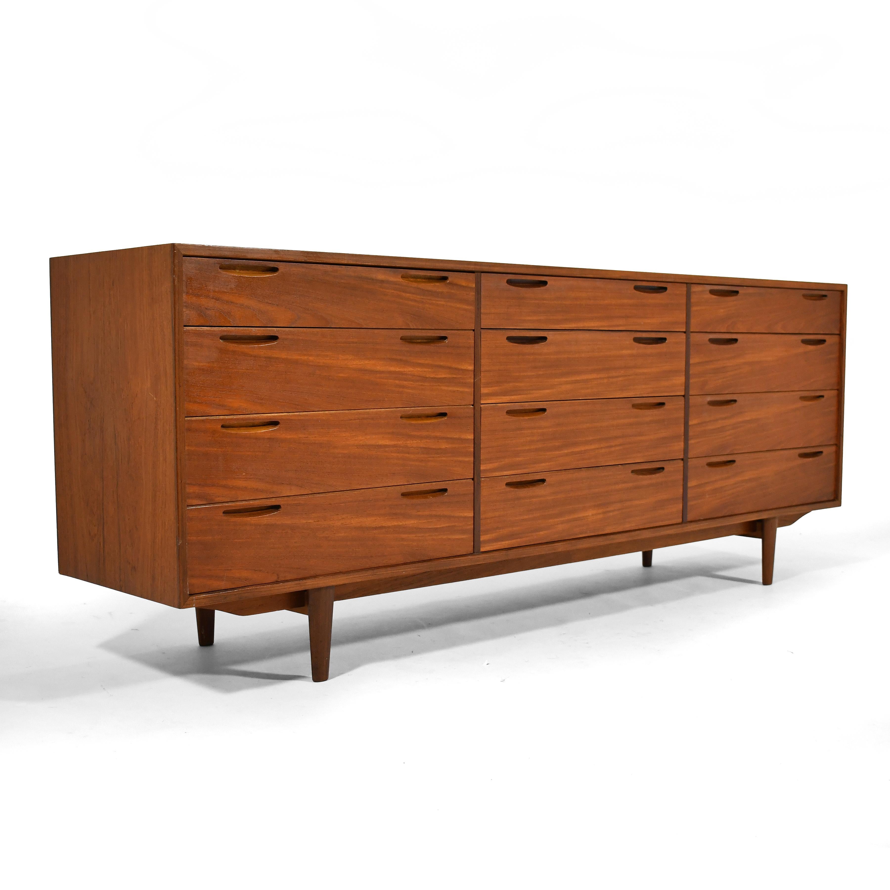 Designed by Ib Kofod-Larsen for Brande Møbelfabrik, this teak 12 drawer cabinet is beautifully constructed with dove-tailed drawer fronts with recessed pulls. It is perfectly suited for use as a dresser, credenza, or chest of drawers. The case is