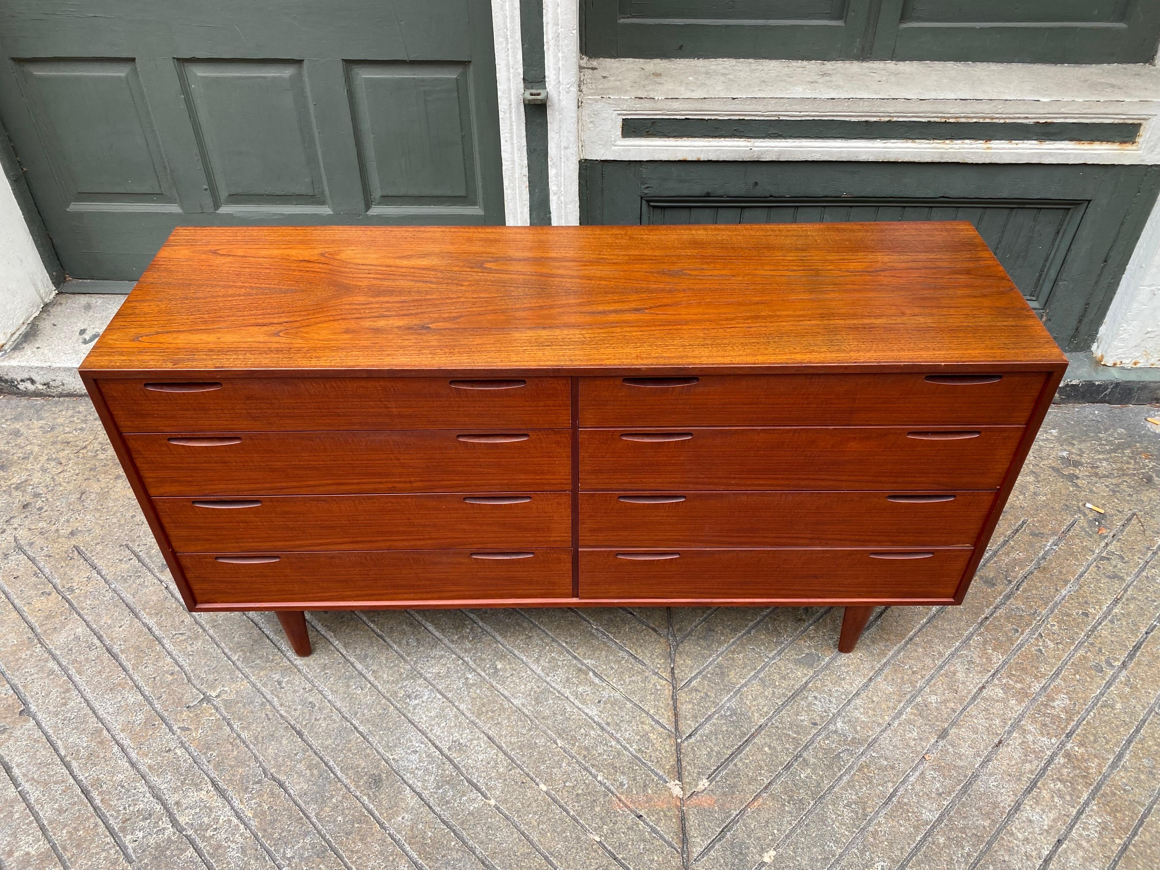 Ib Kofod Larsen 8 Drawer Teak Dresser.  Recessed handles give this piece a very sleek stance.  Top has been refinished, everything else is original.  Very nice quality construction.  Drawers work properly and smoothly.