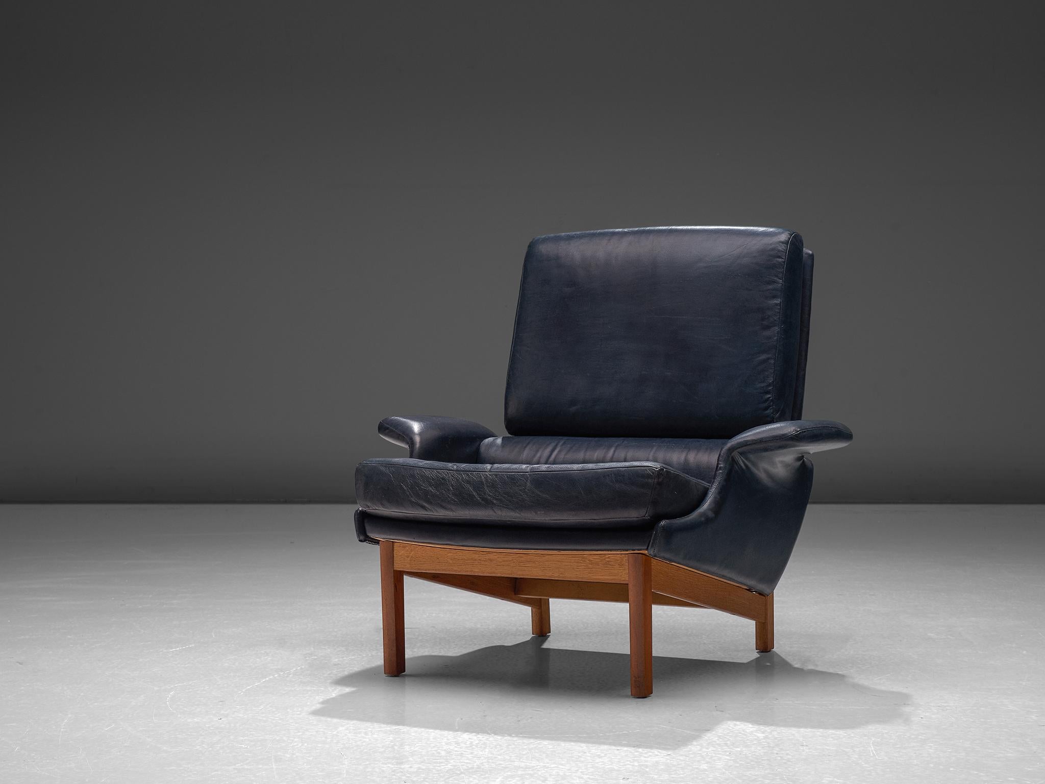 Adam lounge chair, in leather and teak, by Ib Kofod-Larsen for Mogens Kold Møbelfabrik, Denmark, 1958.

This extraordinary and very comfortable set of lounge chairs have a tight and clean body with the folded well known 'wing' armrests. The