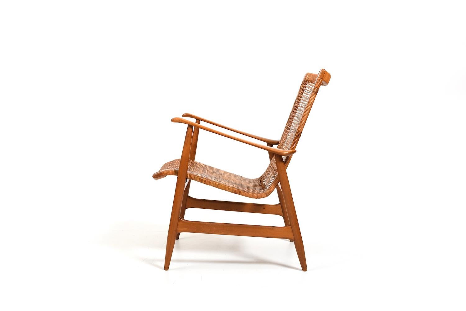 Early 1950s danish easychair with cane and organic shaped form. Made in beech wood. In order to preserve the old structure, we only had a few small broken areas of the cane professionally renewed. The design is reminiscent of IB KOFOD LARSEN but
