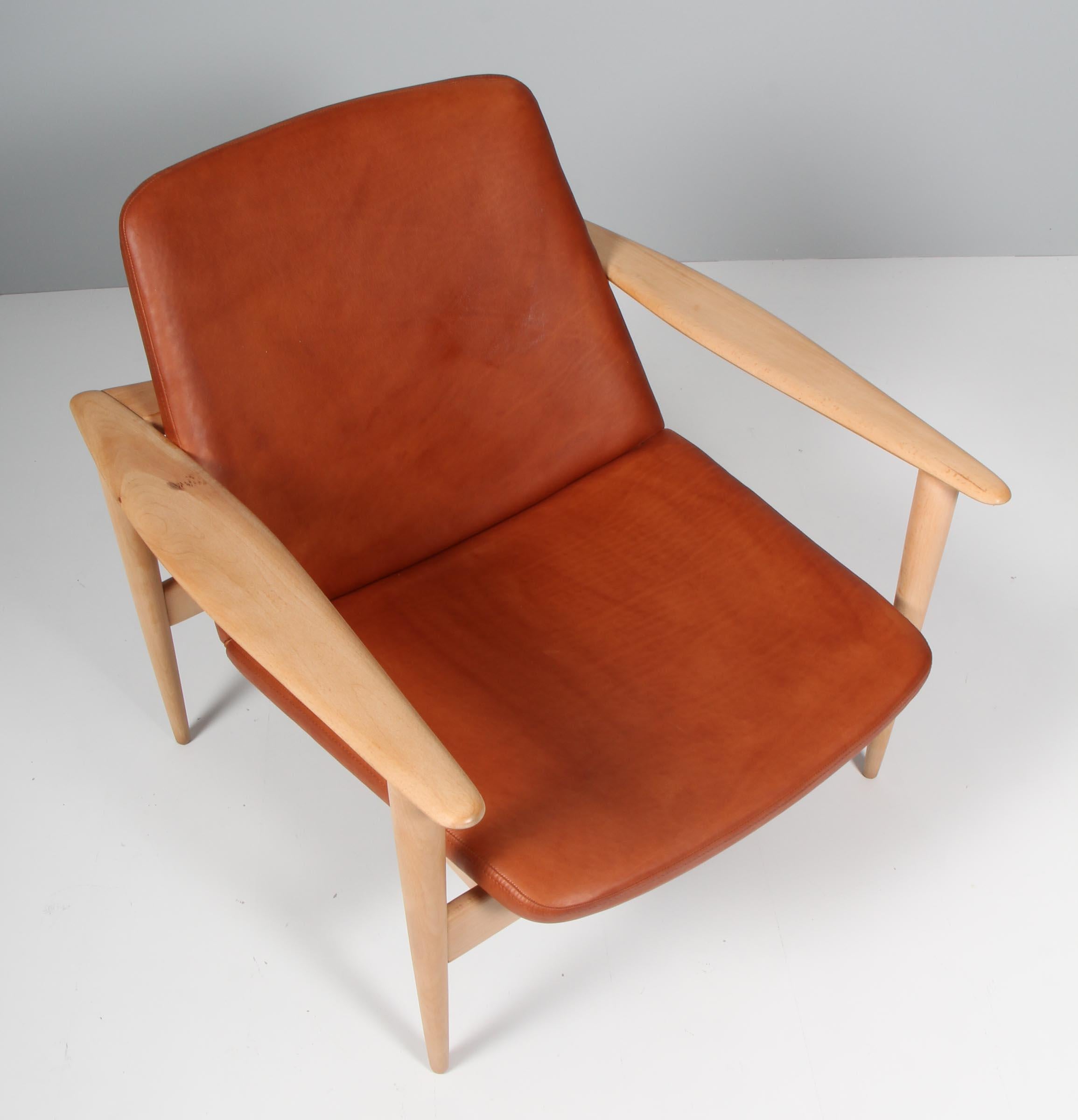 Ib Kofod-Larsen attributed, lounge chair new upholstered with tan aniline leather.

Frame with sculptural arm leans in soap treated beech.

Probably made by Selig.
  