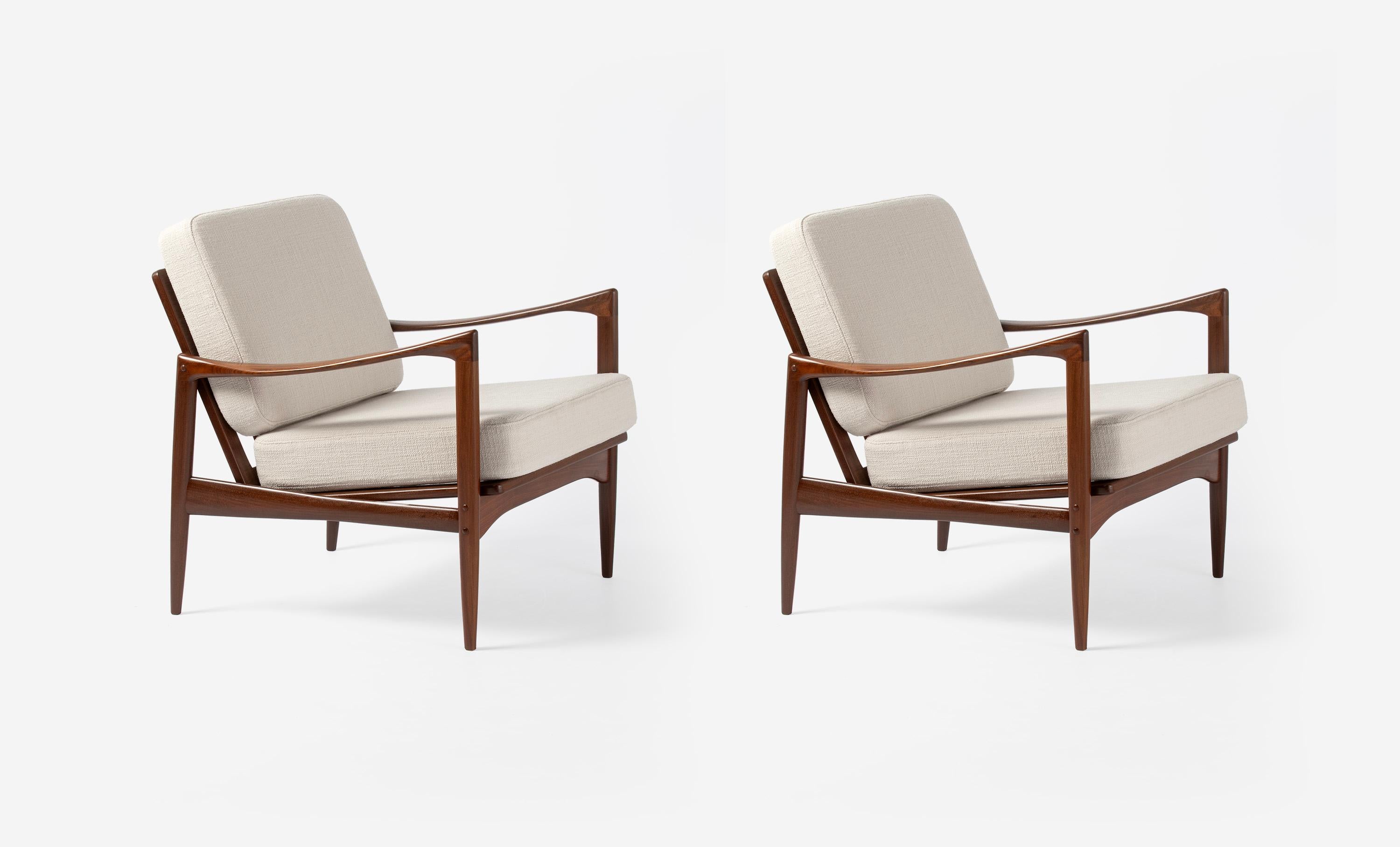 A pair of Afromosia African teak 'Kandidaten', (Candidate), lounge chairs produced by Olof Perssons Fatoljindustri (O.P.E.) in Jonkoping, Sweden, circa 1960. 

Danish master Ib Kofod-Larsen gained popularity in his native Denmark in the 1950s via