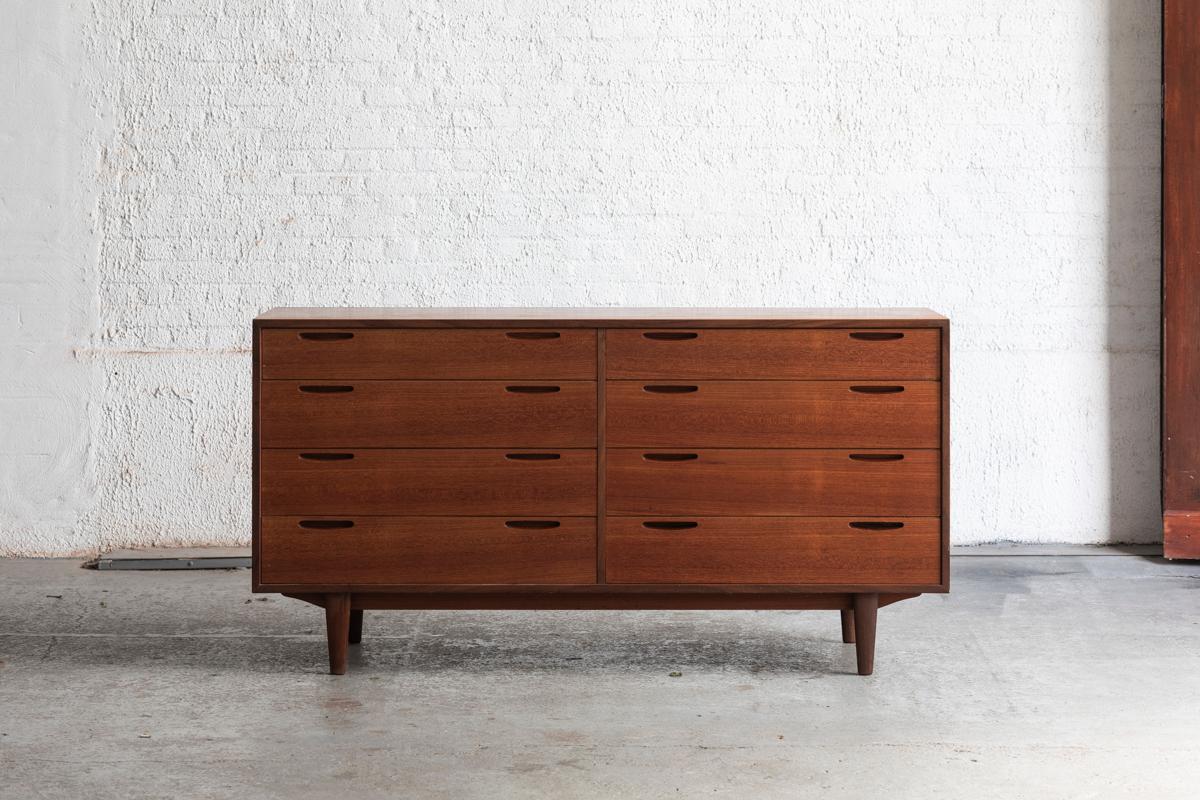 Freestanding chest of drawers designed by Ib Kofod Larsen and produced by Brande Mobelfabrik in Denmark in the 1960’s. It is made of teak and has a high degree of finishing with its sculpted handgrips and a veneered backside. Apart from a