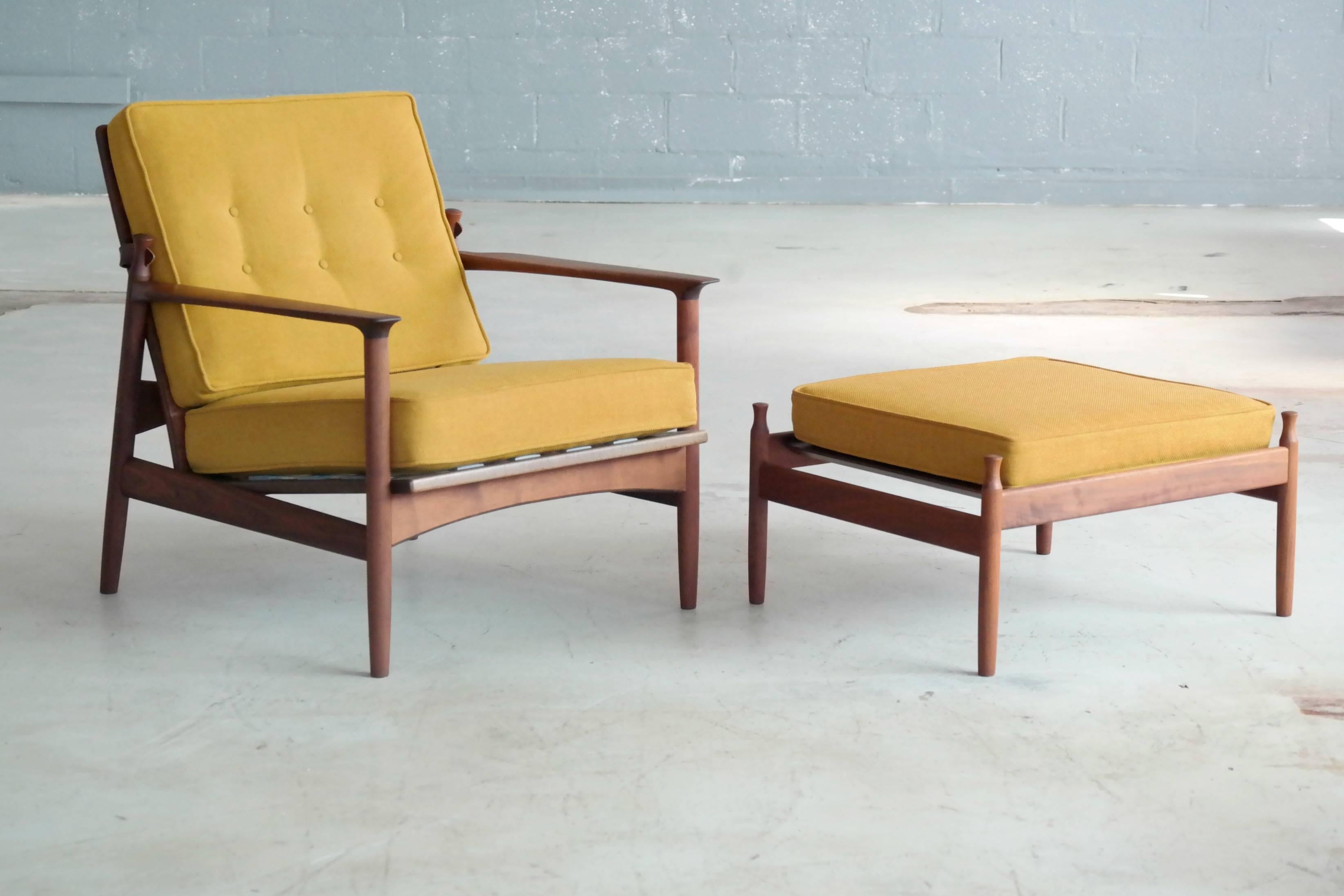 Rare 1950s easy chair originally designed by famed Danish Designer, Ib Kofod-Larsen for US retailer, Selig. The chair features a very distinct design based on a beautiful walnut frame with oblong cut-outs in the backrest through which the mustard