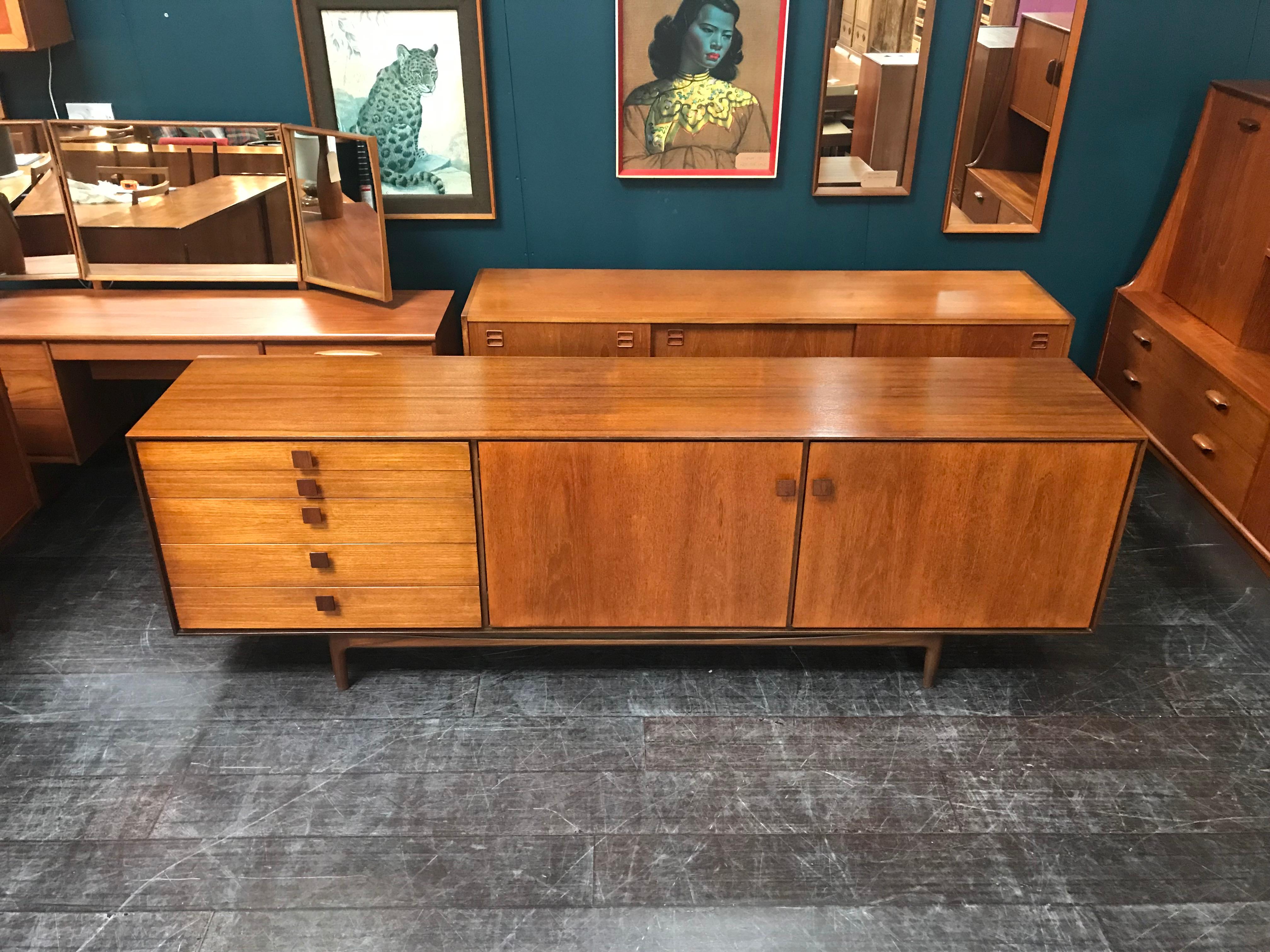 A very cool sideboard designed by the Danish Designer Ib Kofod Larsen for English maker G Plan. Made of a warm teak with beautiful lines and plenty of storage space, this vintage midcentury sideboard has 5 drawers and shelved cupboards. A