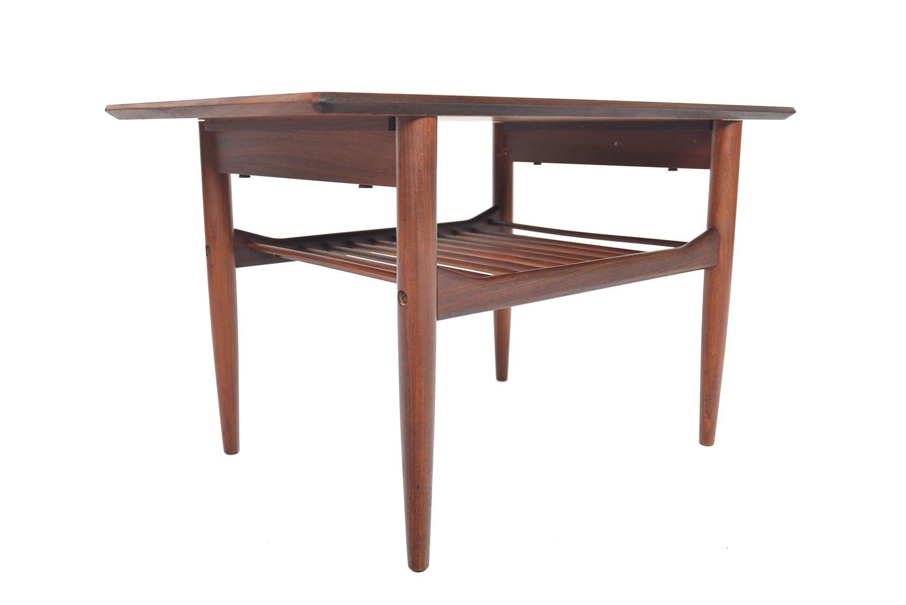 Designed by Ib Kofod- Larsen for G Plan’s Danish range in the 1960s, perfectly detailed side table is crafted in old- growth teak. A lower doweled rack provides storage. In excellent original condition.
  