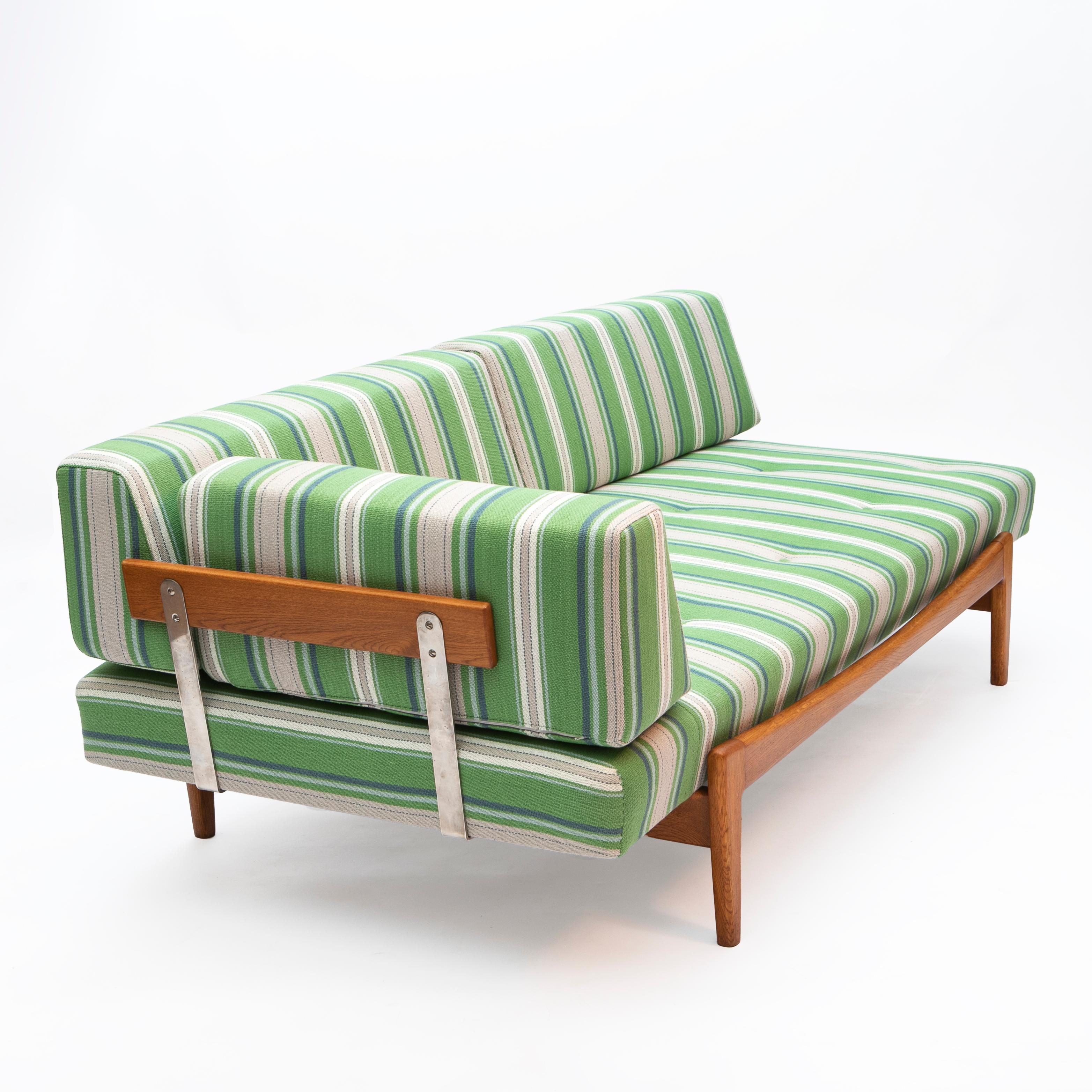 Ib Kofod-Larsen 1922-2003.
Sofa / daybed in solid teak designed by Ib Kofod-Larsen. Produced by Seffle Möbelfabrik in Sweden, 1960s.

The back rest and side rest are supported by steel bars.

Newly upholstered with striped textile from Jane