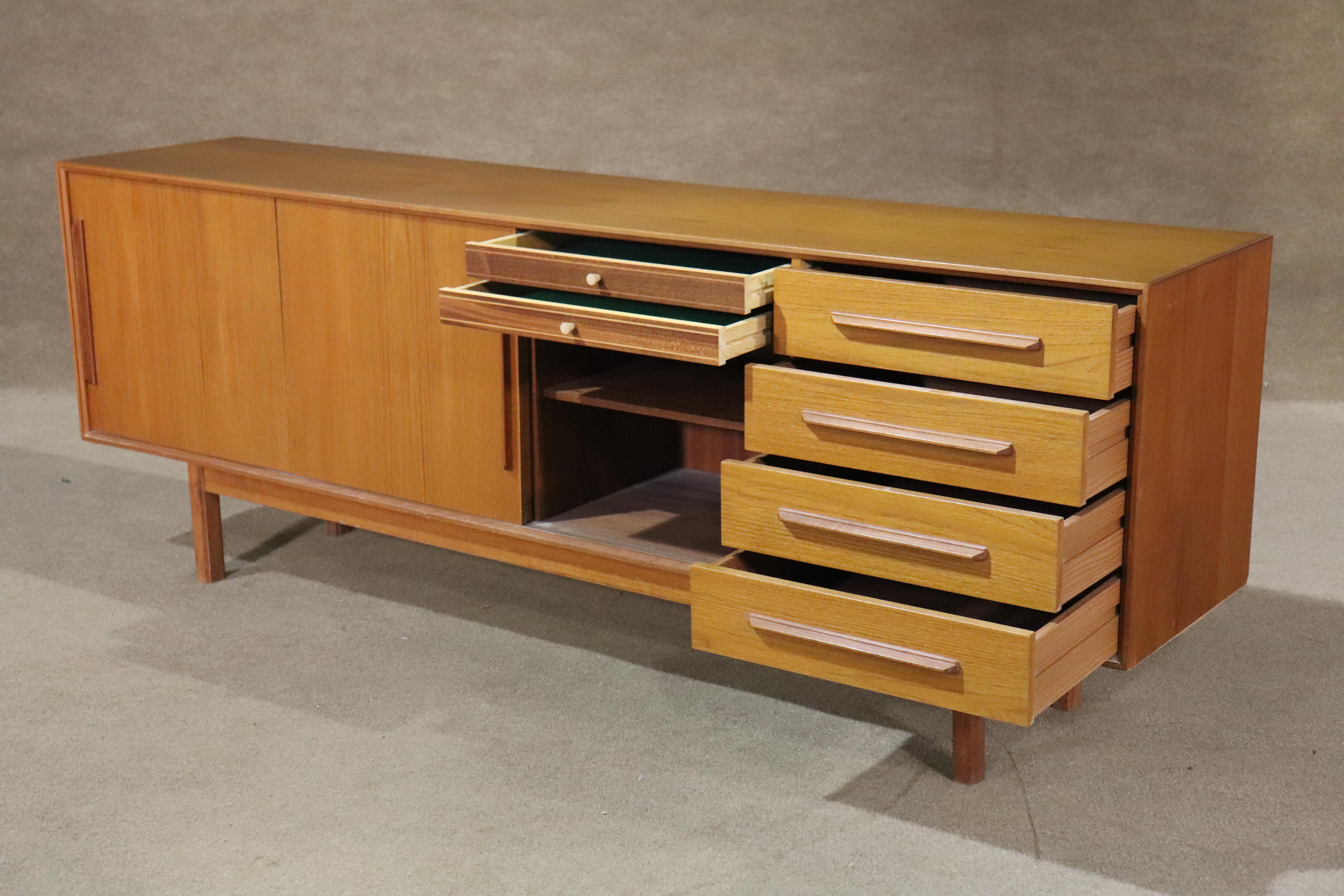 Ib-Kofod Larsen for Faarup Møbelfabrik long sideboard, made in Denmark. Beautiful teak grain throughout with sculpted wood handles. Ample storage with cabinets space and drawers.
Please confirm location NY or NJ