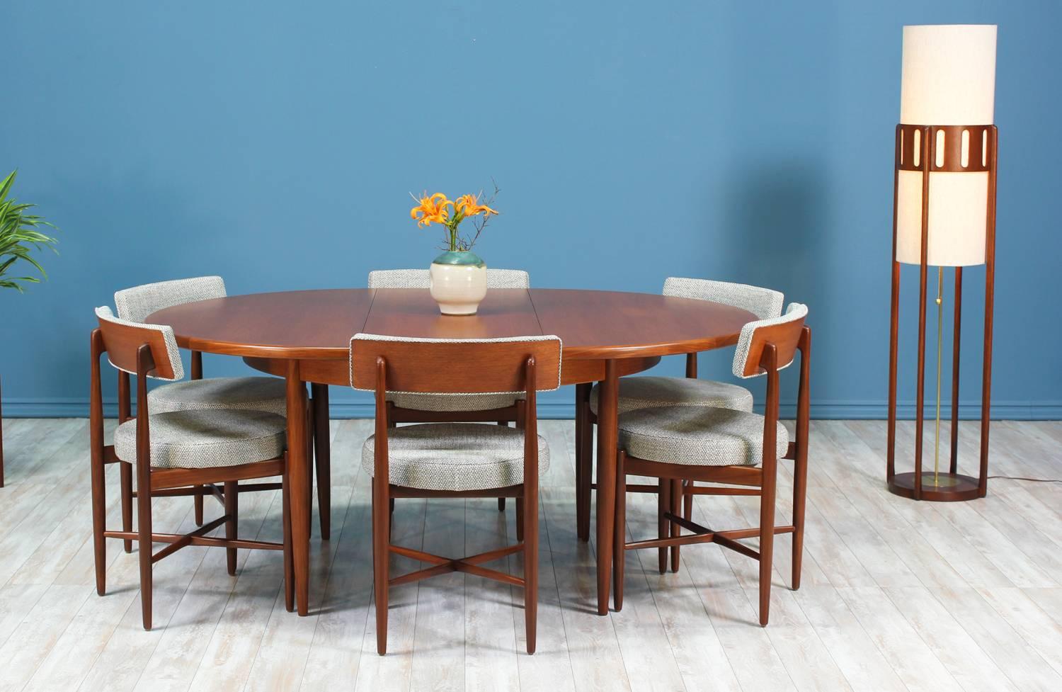 Beautiful dining set consisting of six teak chairs and a butterfly leaf table designed by Danish designer Ib Kofod-Larsen for G-Plan in England circa 1960’s. All six chairs are in excellent restored condition featuring their original solid teak wood