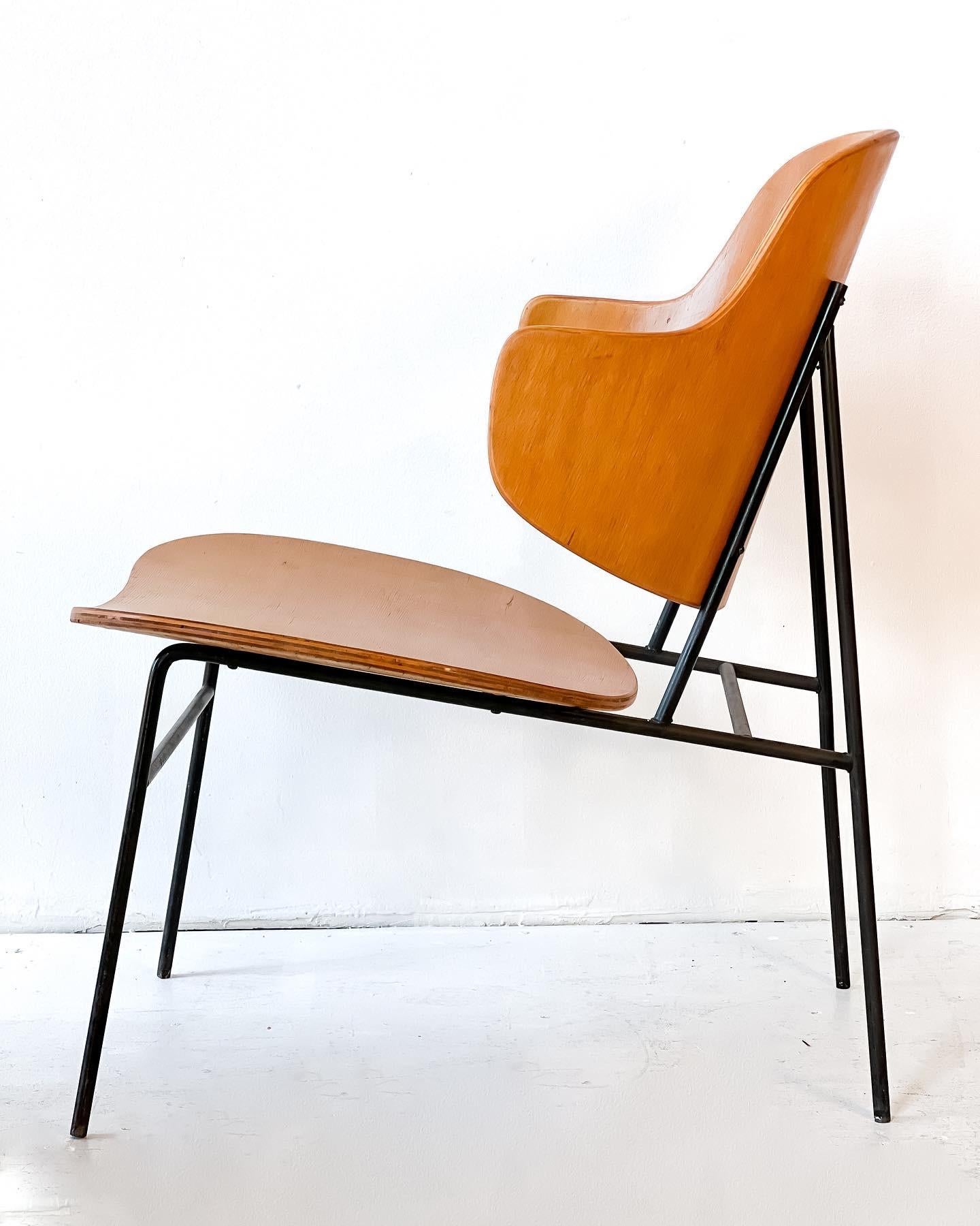 Iconic steam-molded plywood “Penguin” chair by Ib Kofod-Larsen. On iron frame.
Early model- all plywood wood shell on iron base. This chair comes with great character to be used as it is presented or one may choose to upholster the seat portion.